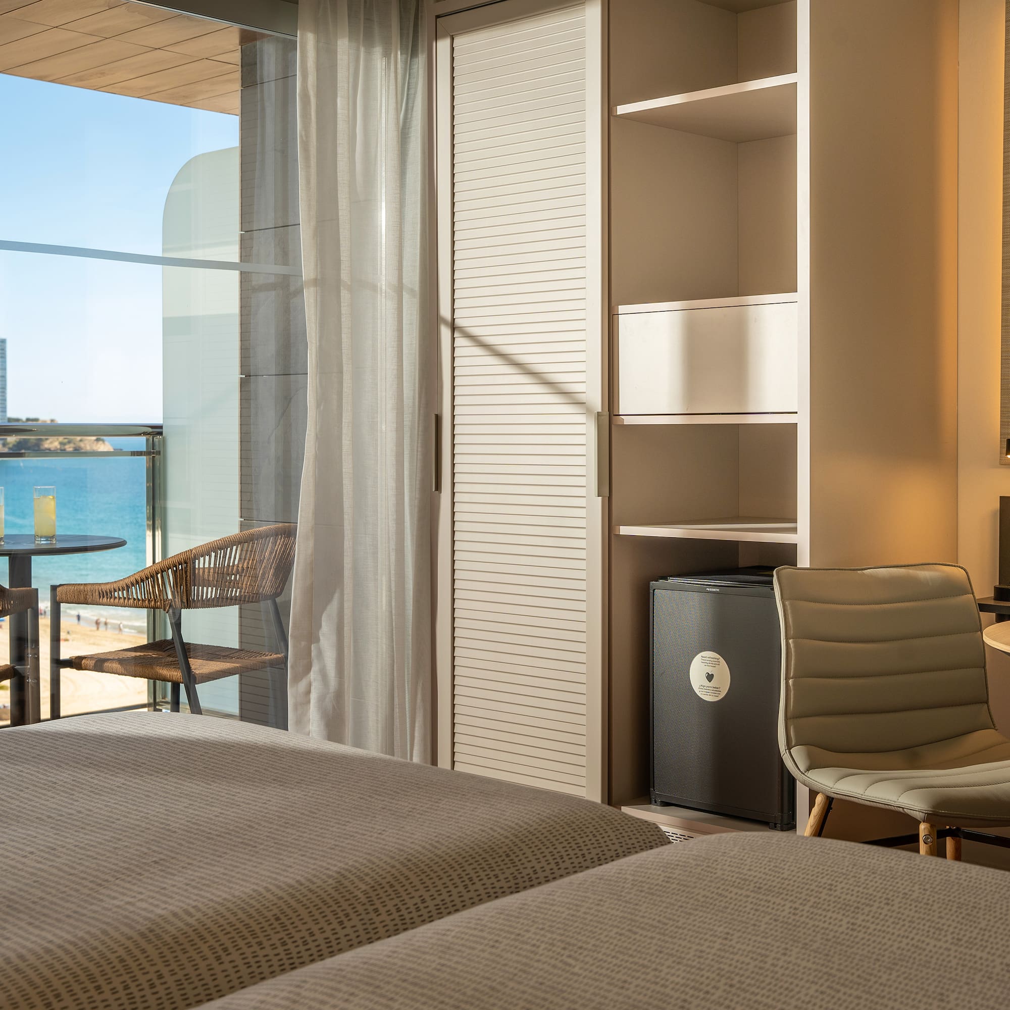 a room with a view of the ocean and a table and chairs