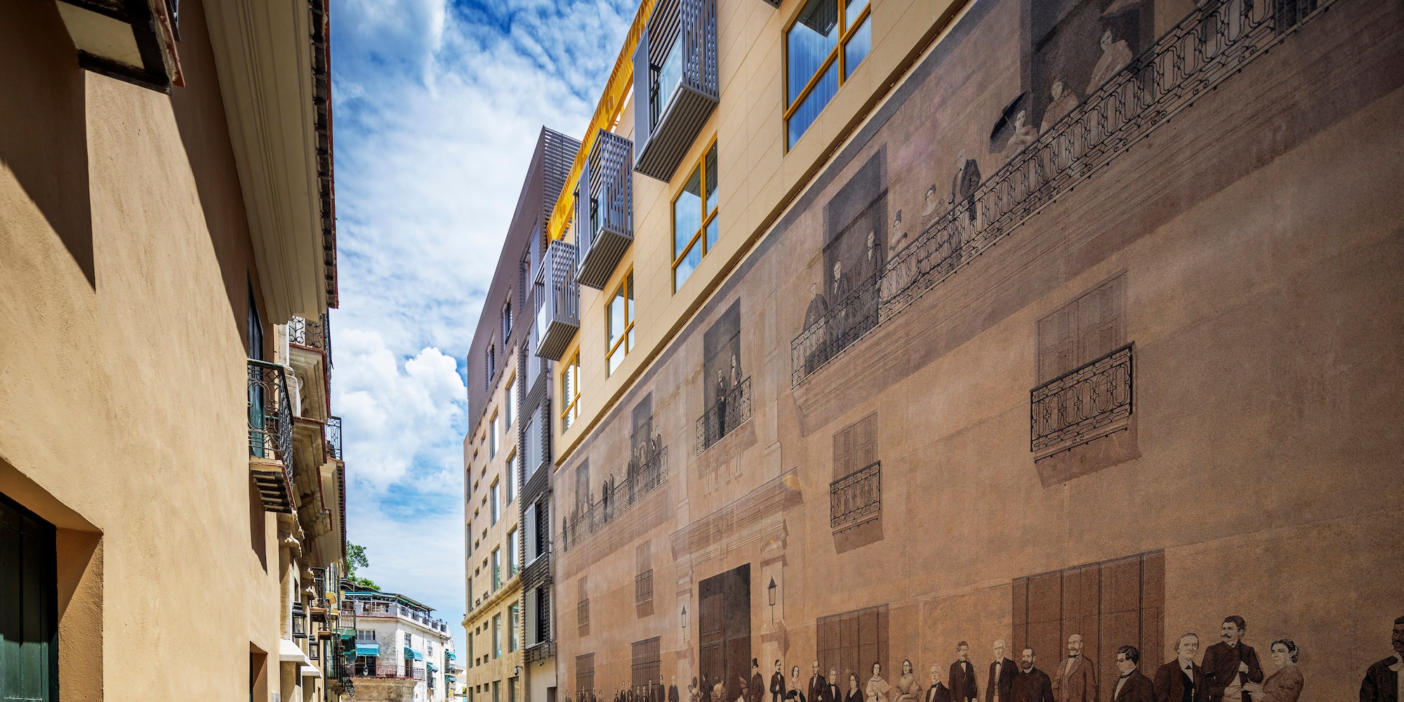 a street with a mural on the side of a building