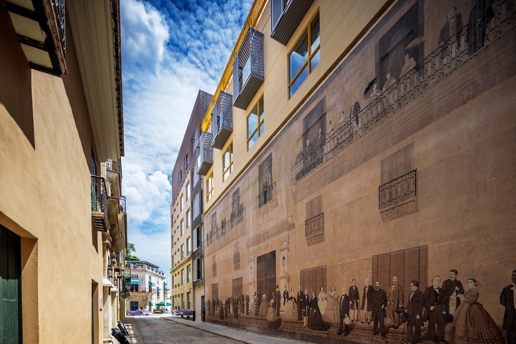a street with a mural on the side of a building