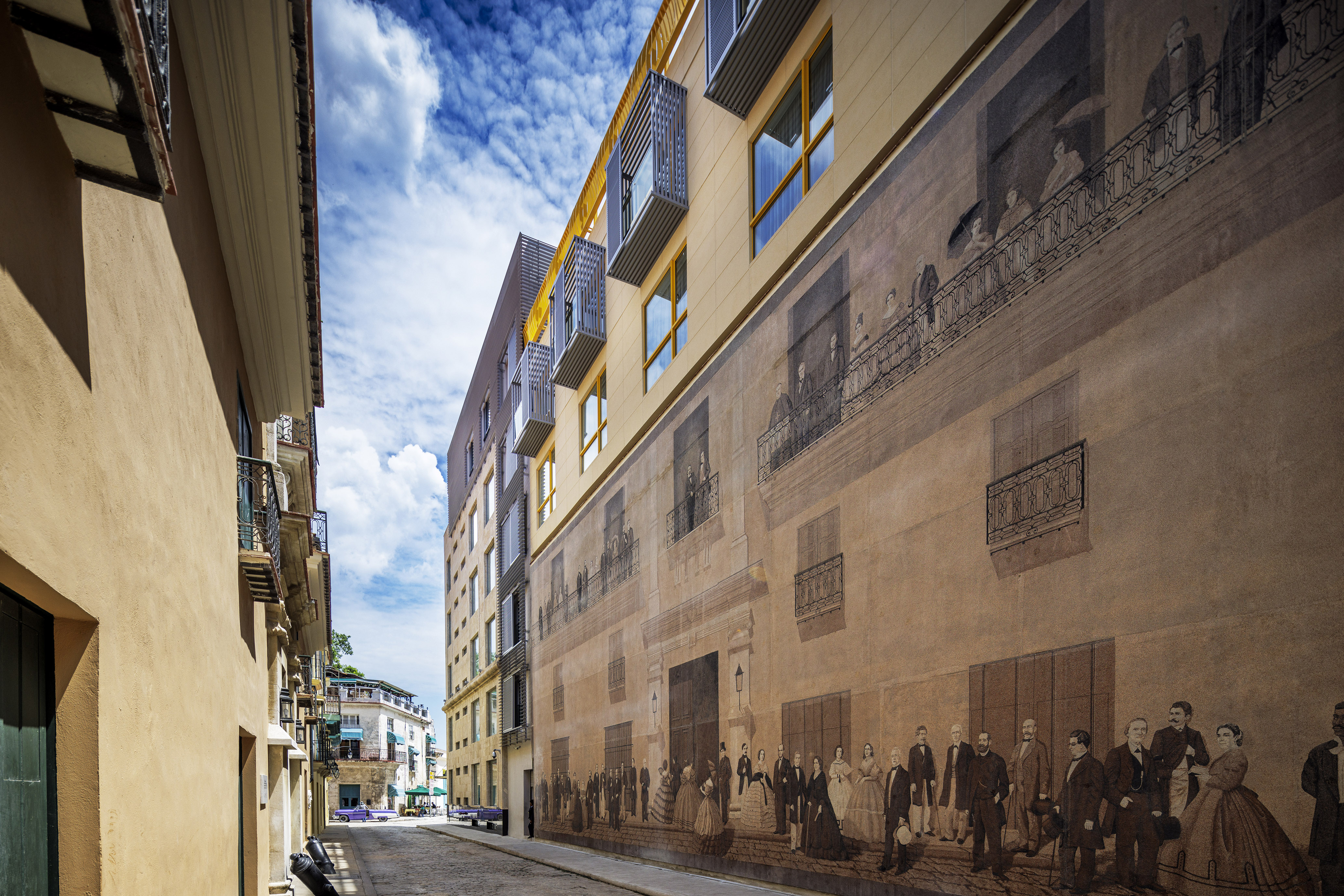 a street with a mural on the side of a building