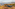 Grey 4x4 on a rocky coastal track, Mediterranean sea, distant village.