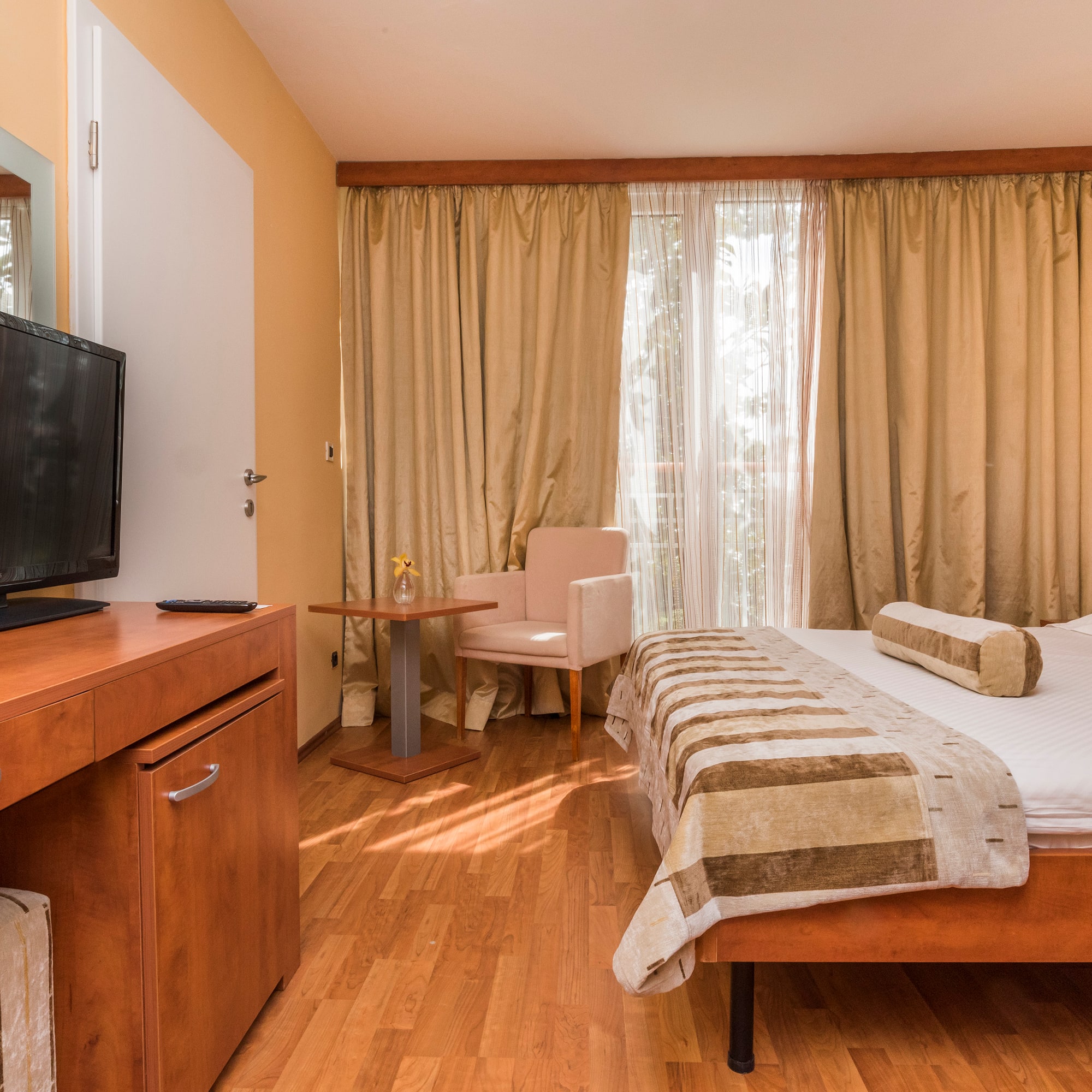 a room with a bed and a television