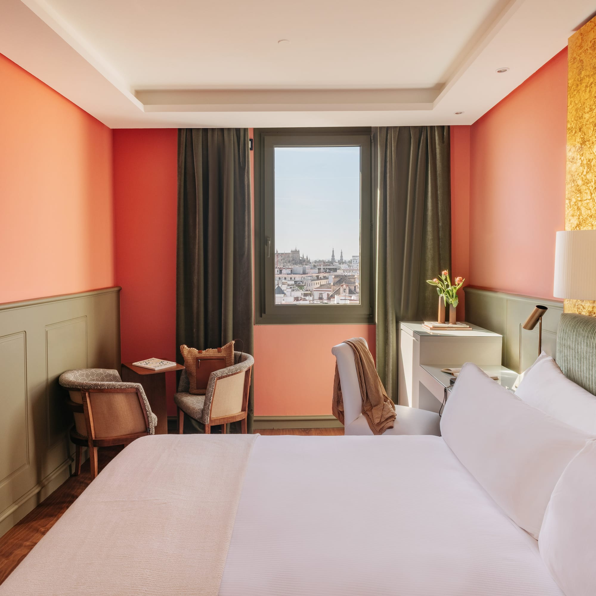 a room with a bed and chairs and a window