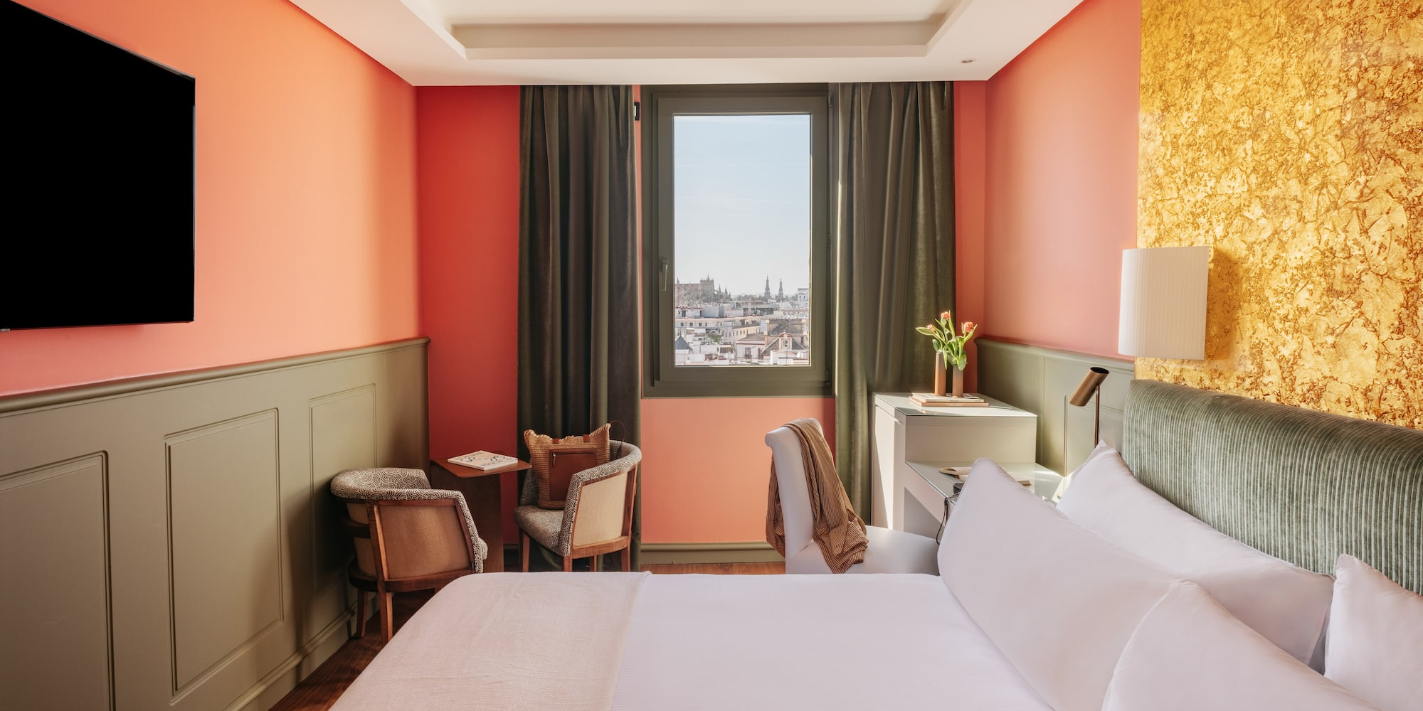 a room with a bed and chairs and a window