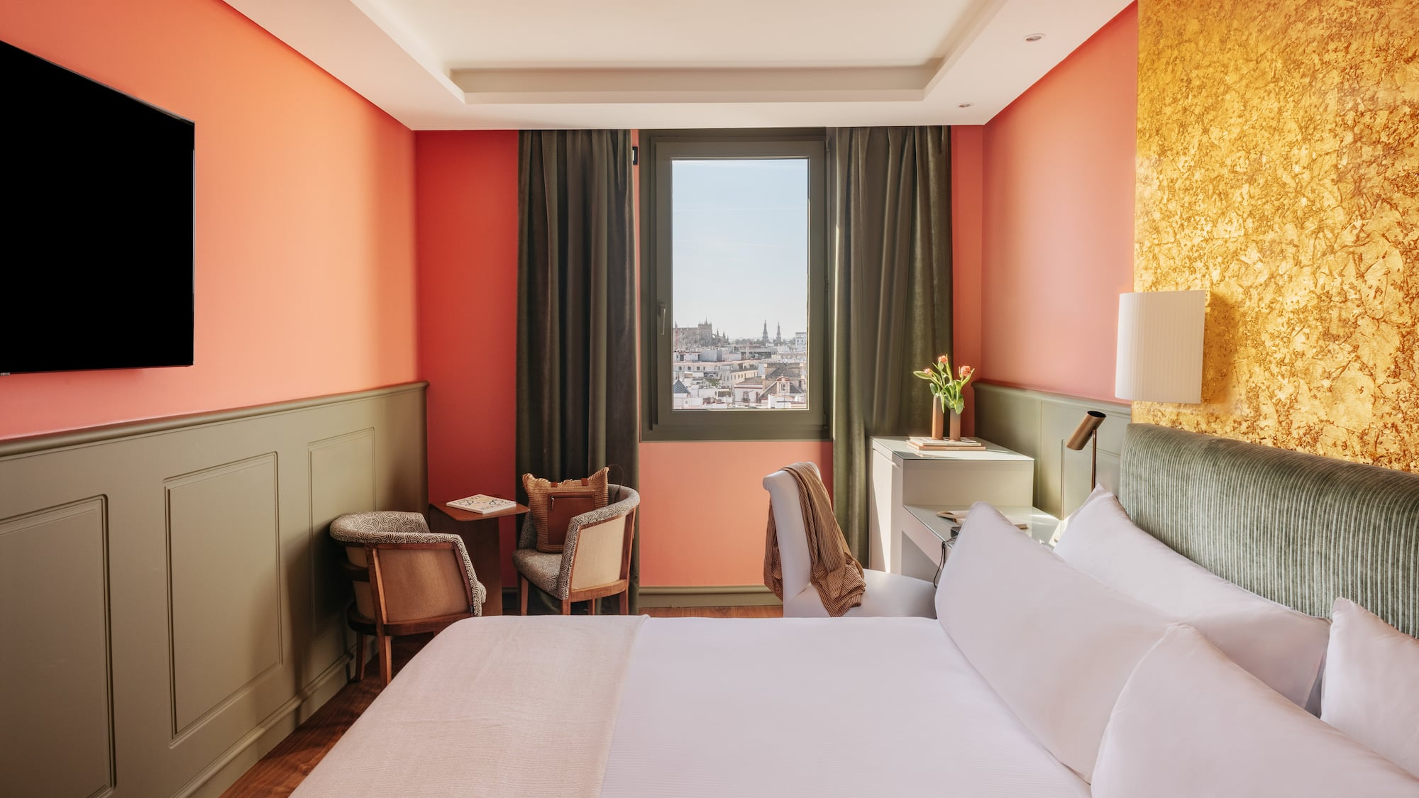 a room with a bed and chairs and a window