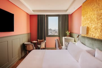 a room with a bed and chairs and a window