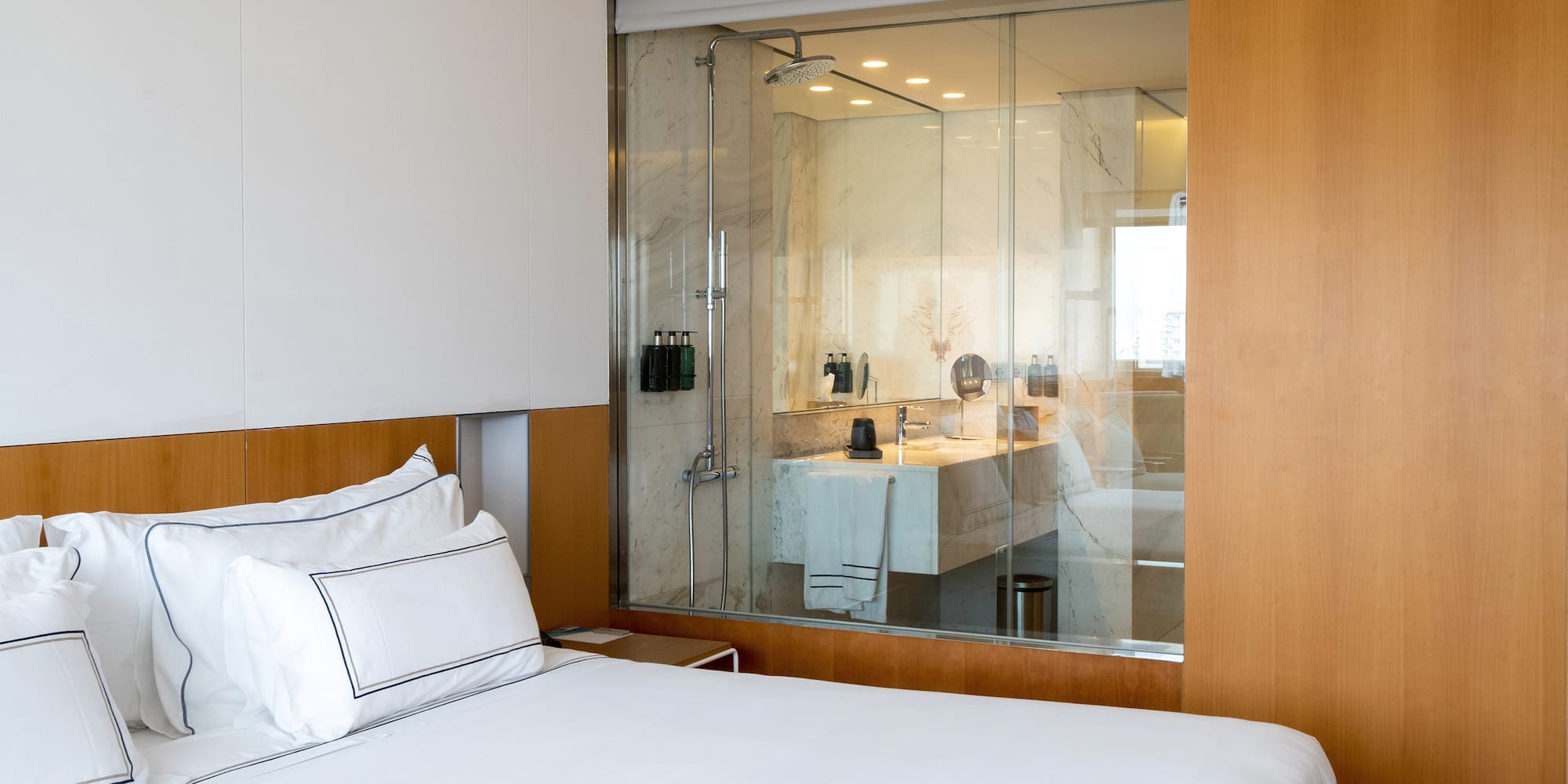 a bed with a glass wall behind it