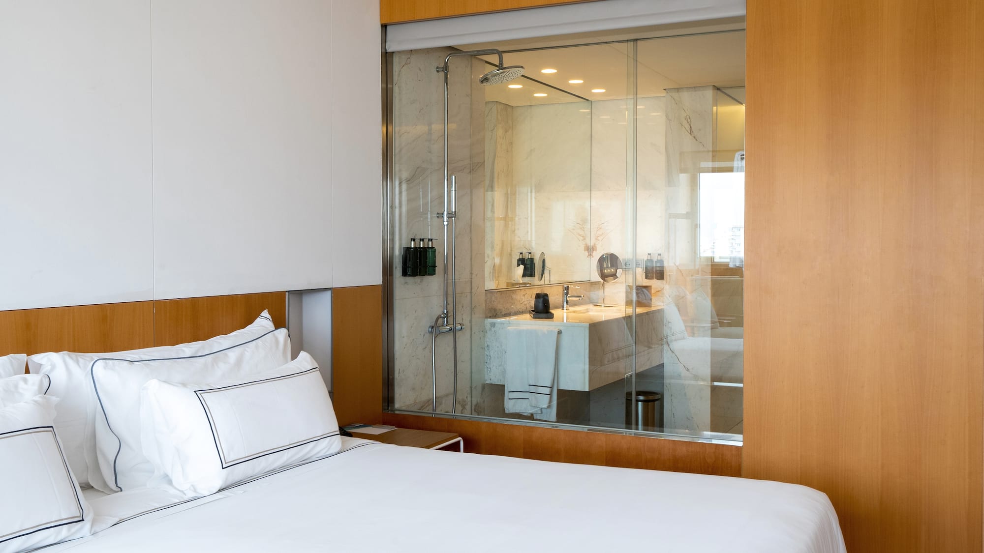 a bed with a glass wall behind it