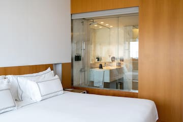 a bed with a glass wall behind it