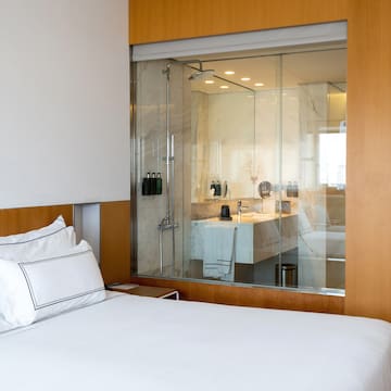 a bed with a glass wall behind it