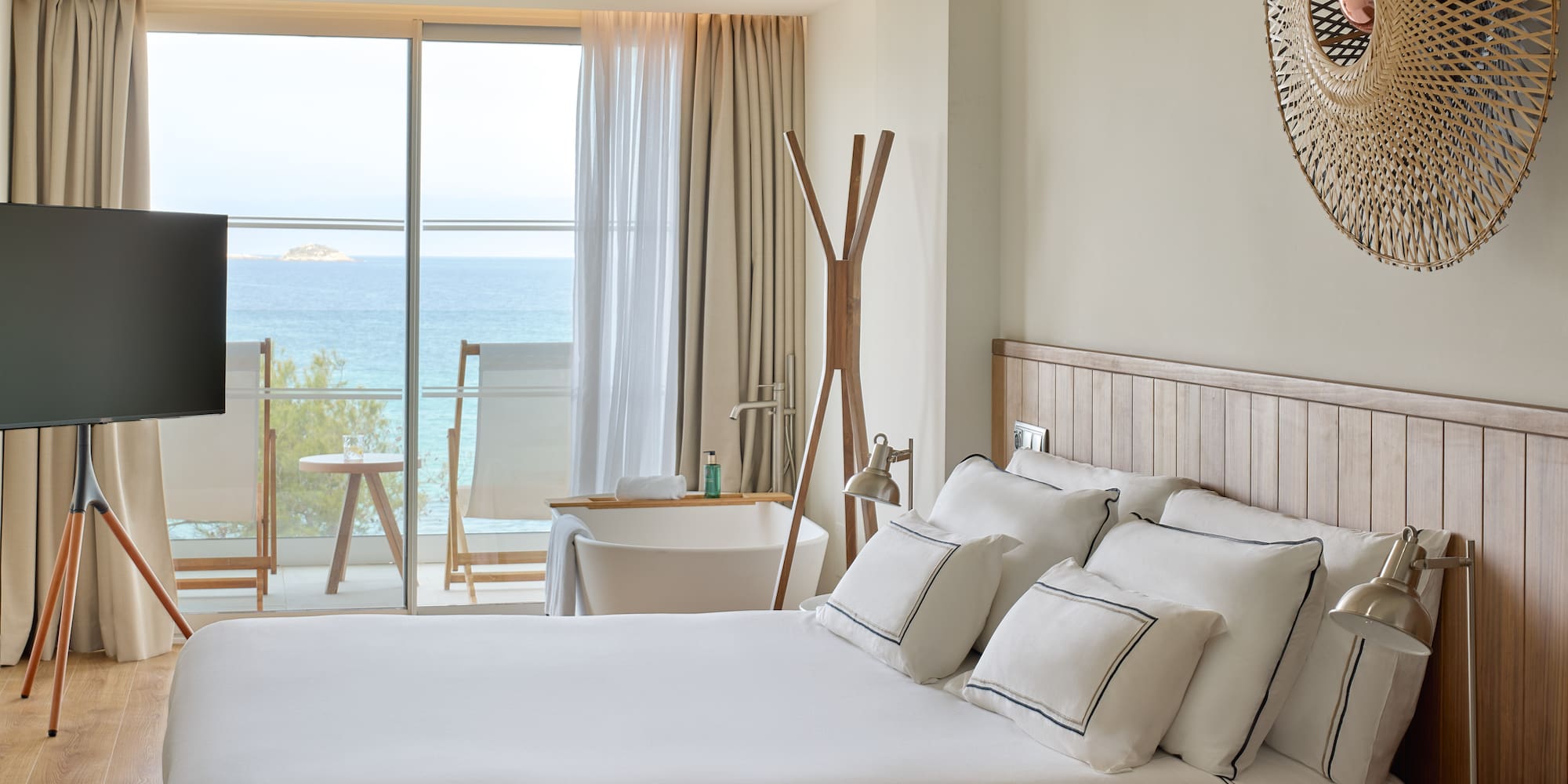a bedroom with a large window overlooking the ocean