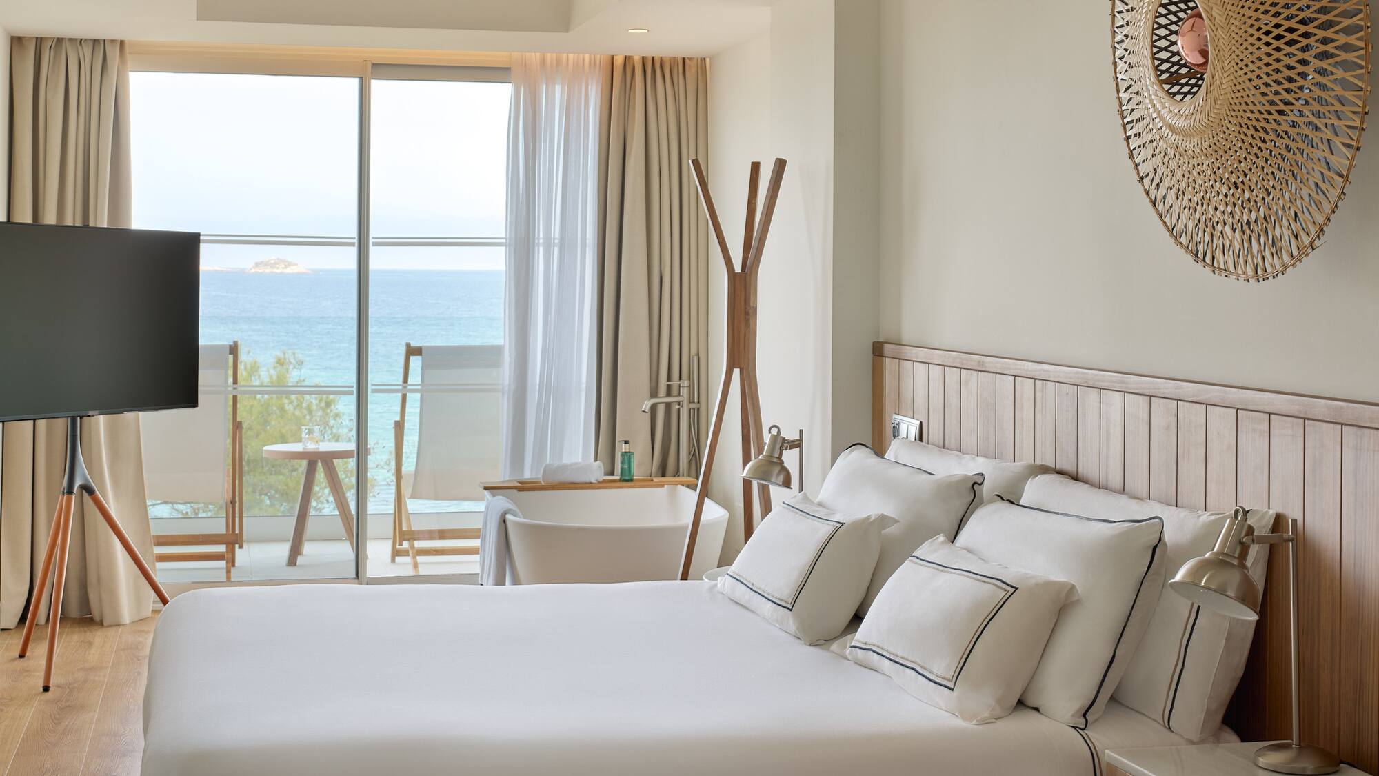 a bedroom with a large window overlooking the ocean