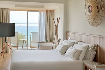 a bedroom with a large window overlooking the ocean