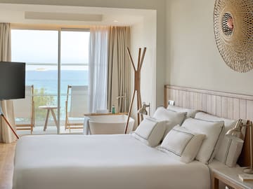 a bedroom with a large window overlooking the ocean