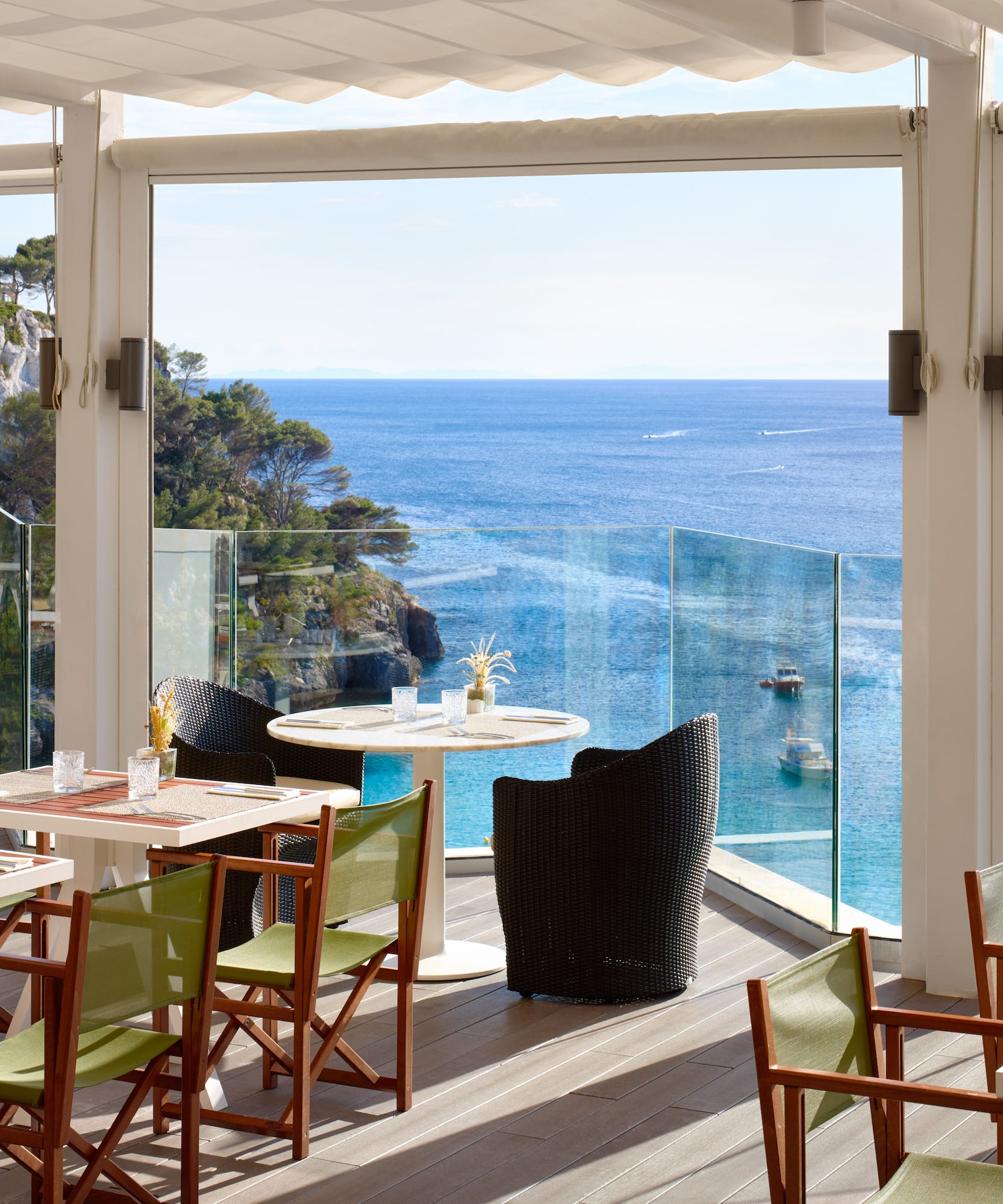 a restaurant with tables and chairs overlooking the ocean