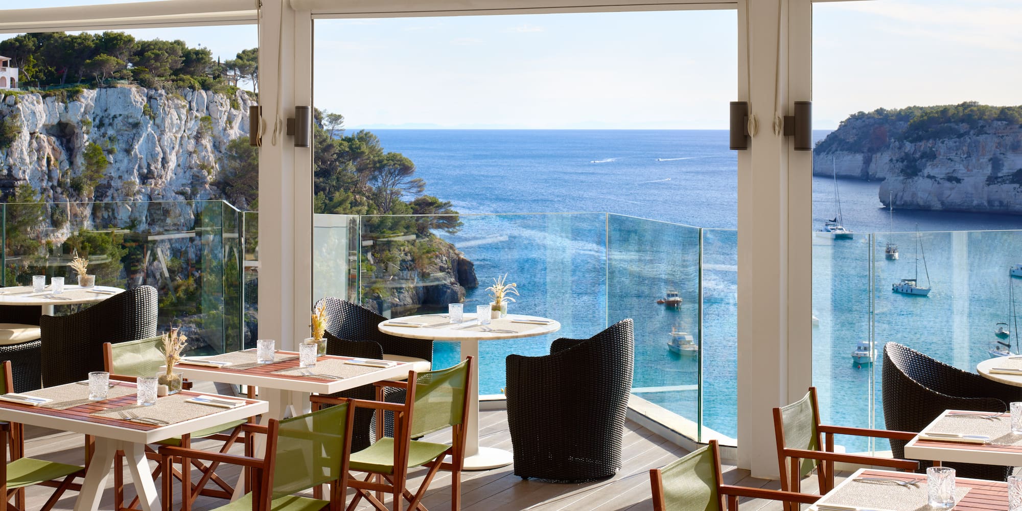 a restaurant with tables and chairs overlooking the ocean