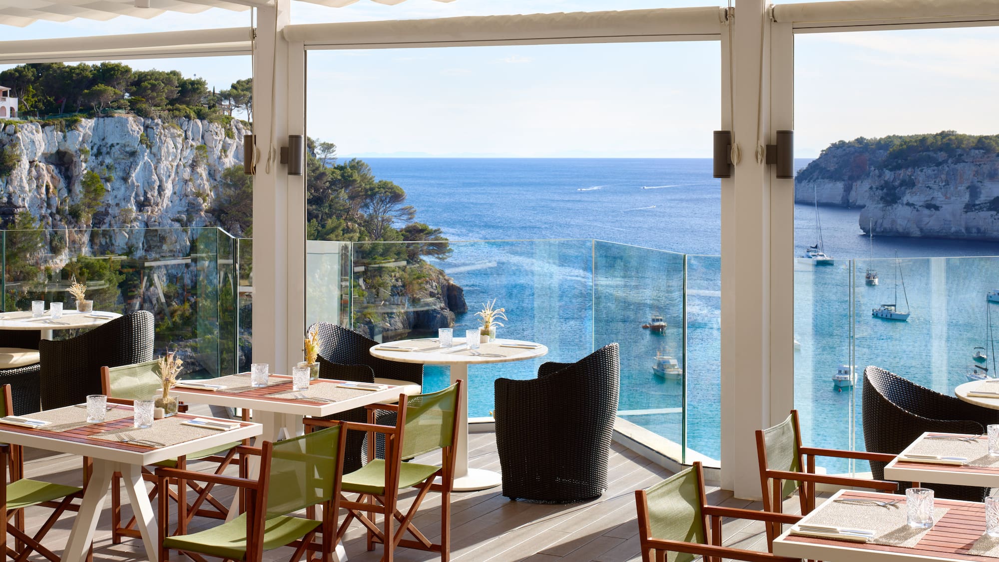 a restaurant with tables and chairs overlooking the ocean