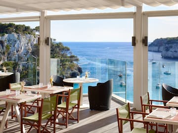 a restaurant with tables and chairs overlooking the ocean