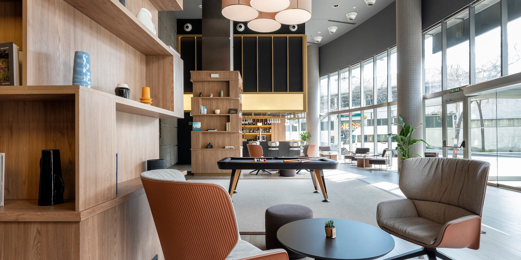 a room with a pool table and chairs