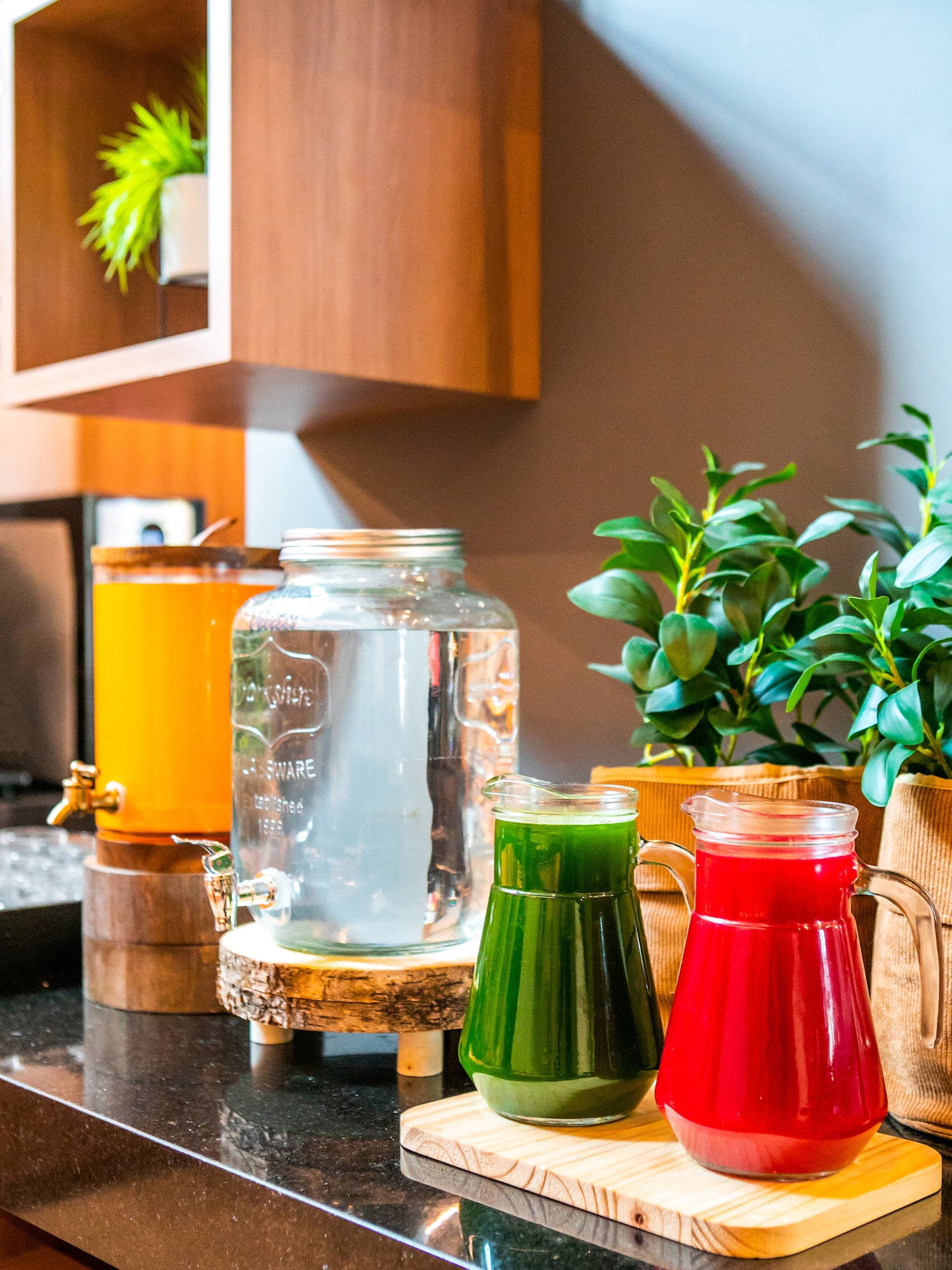 a group of different colored drinks in a glass jar