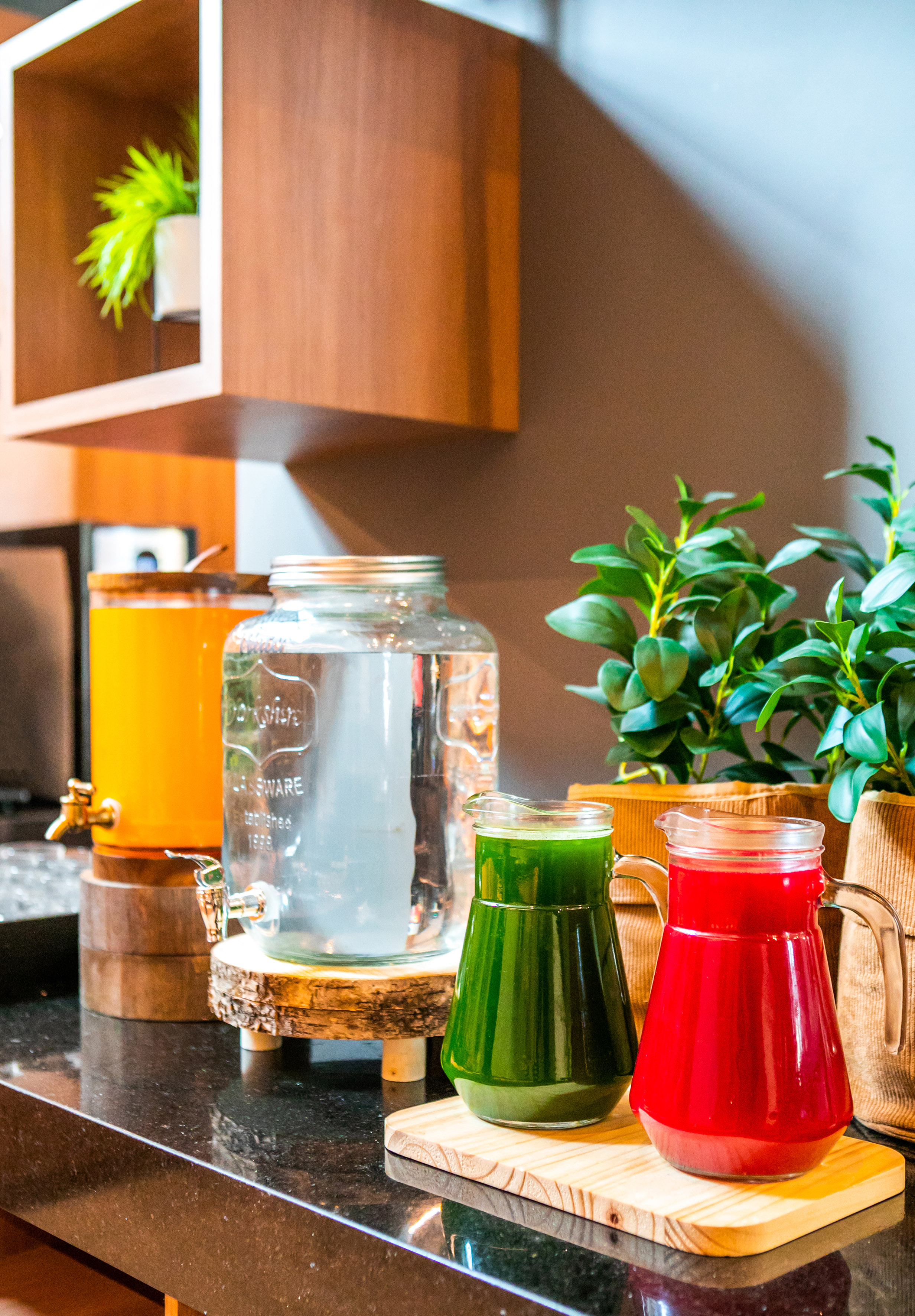 a group of different colored drinks in a glass jar