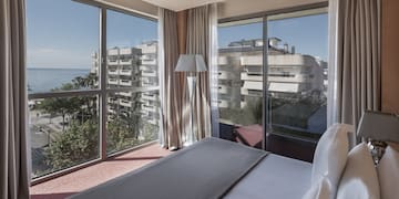 a bedroom with large windows and a view of the ocean