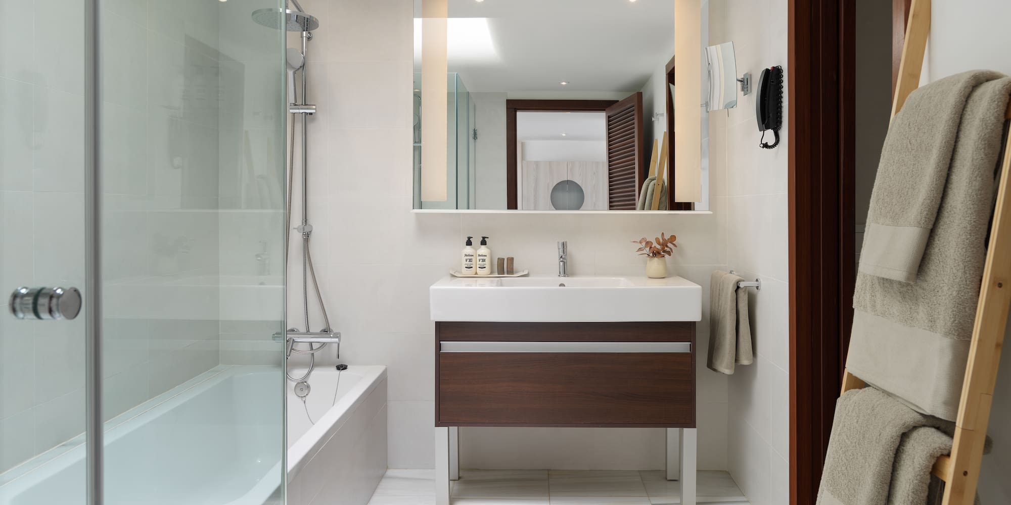 a bathroom with a glass shower door and a sink