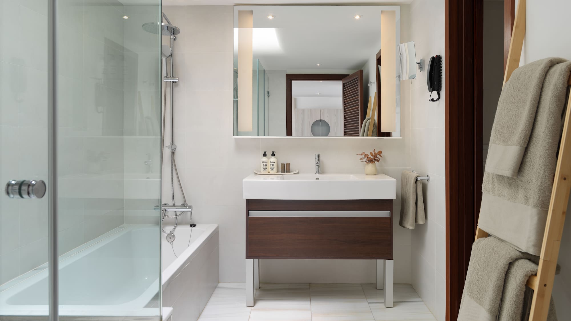 a bathroom with a glass shower door and a sink