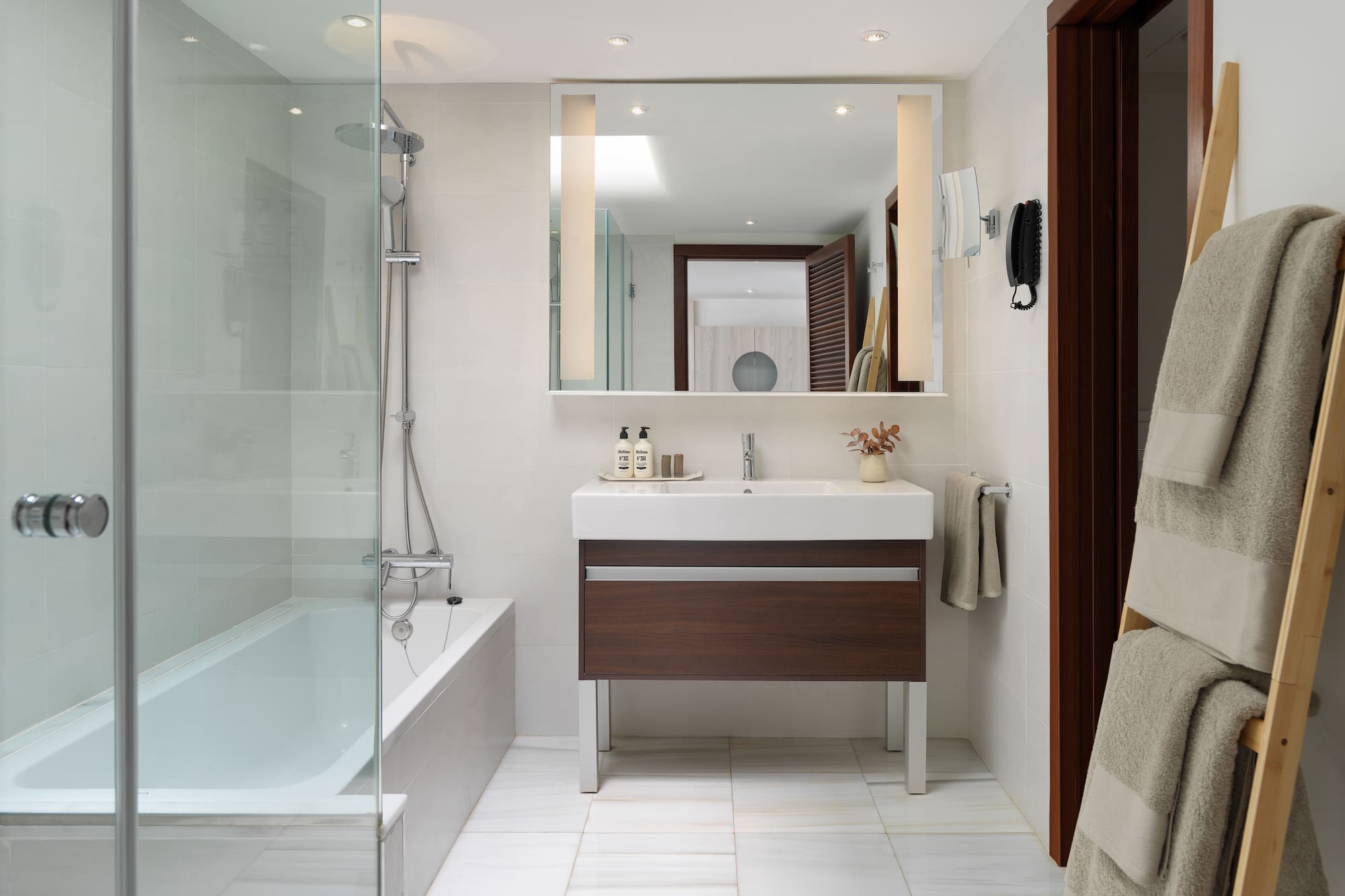 a bathroom with a glass shower door and a sink