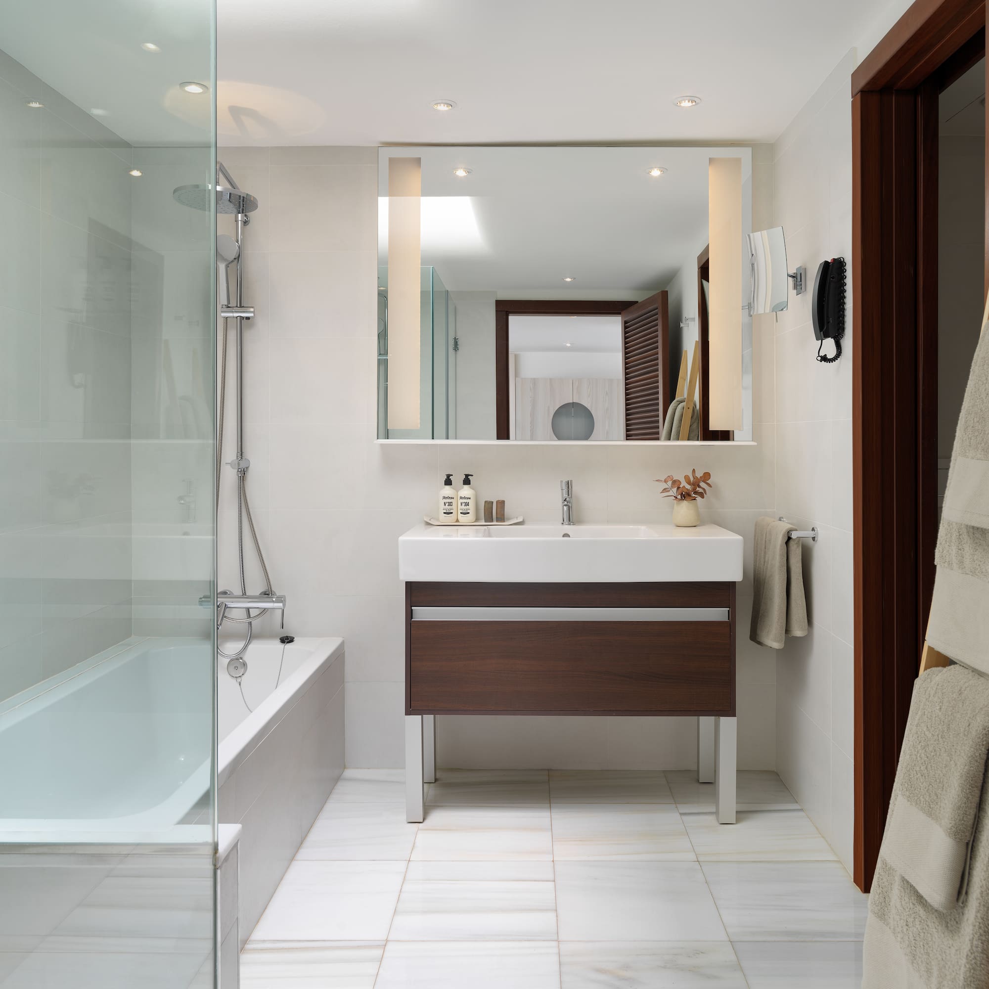 a bathroom with a glass shower door and a sink