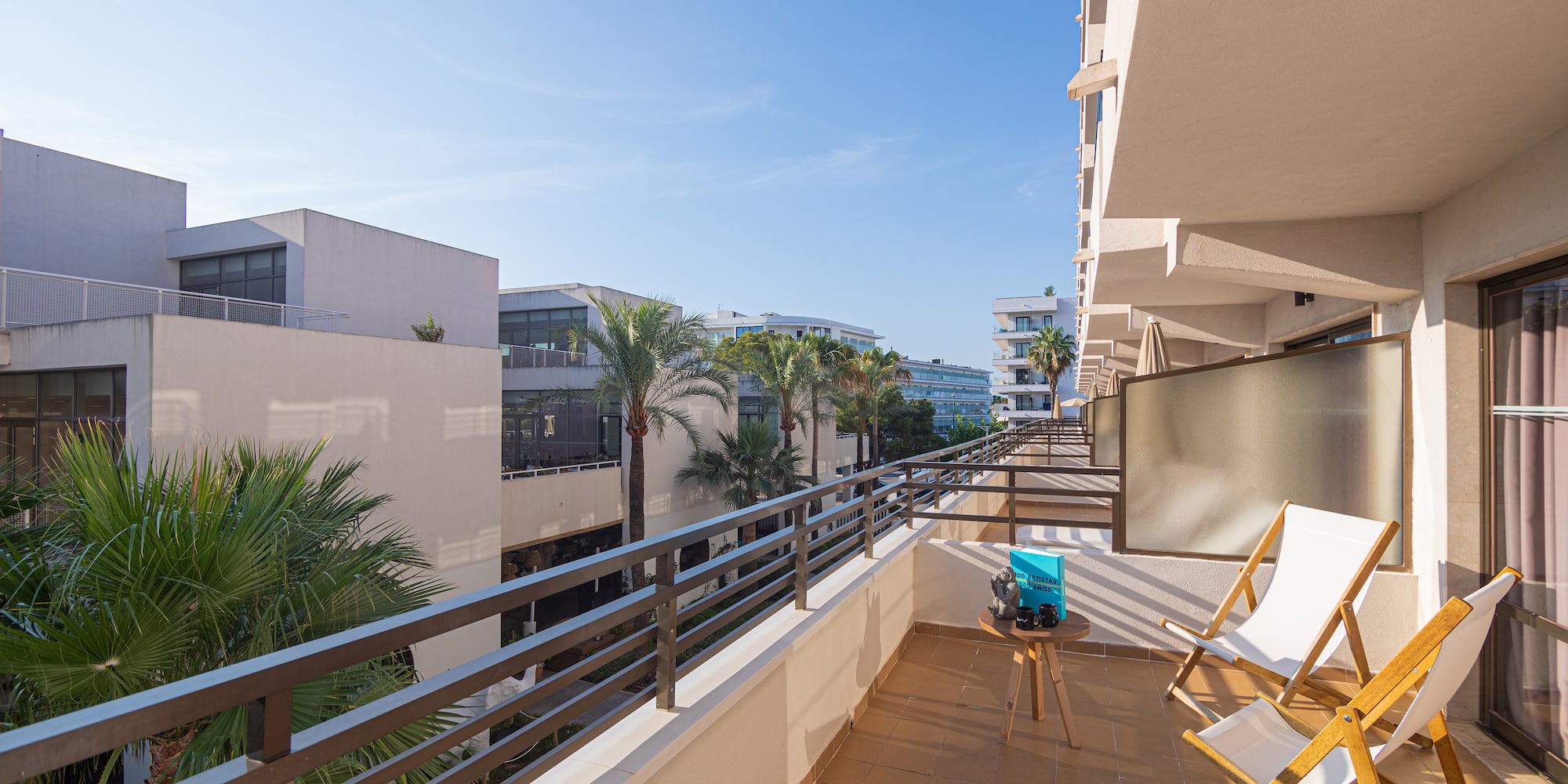 a balcony with chairs and a table and a television