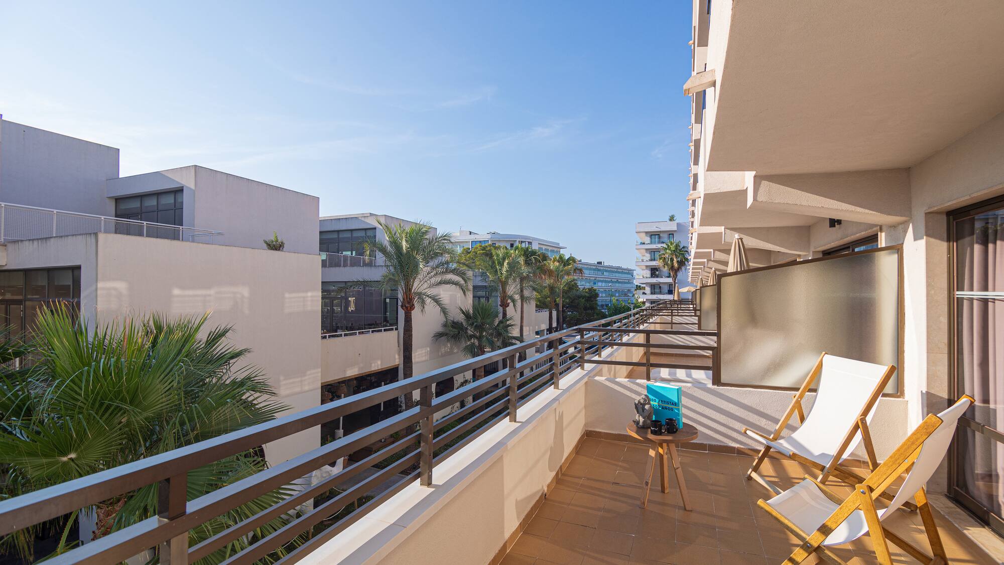 a balcony with chairs and a table and a television