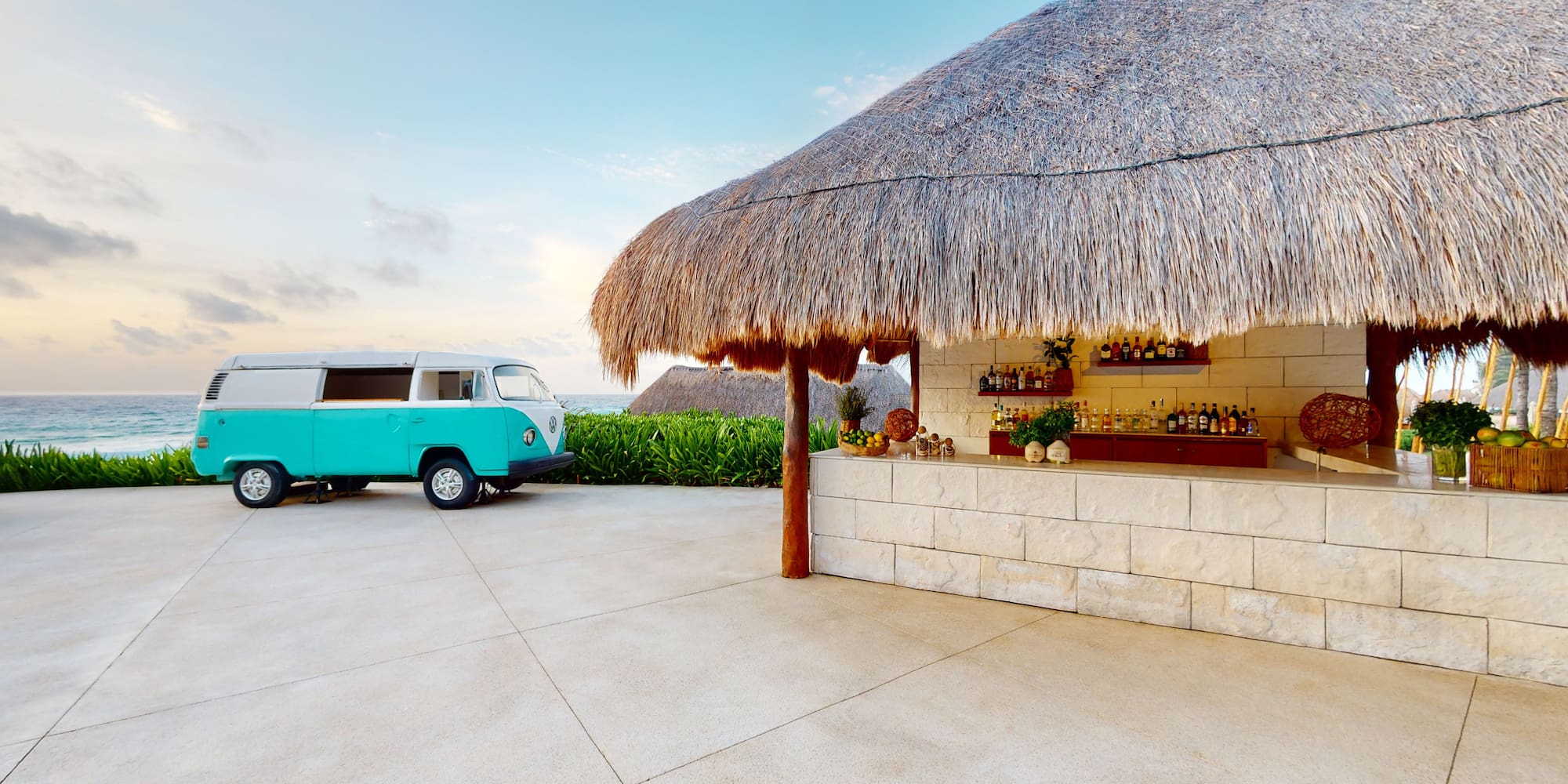 a bar with a blue van parked in front of a thatched roof