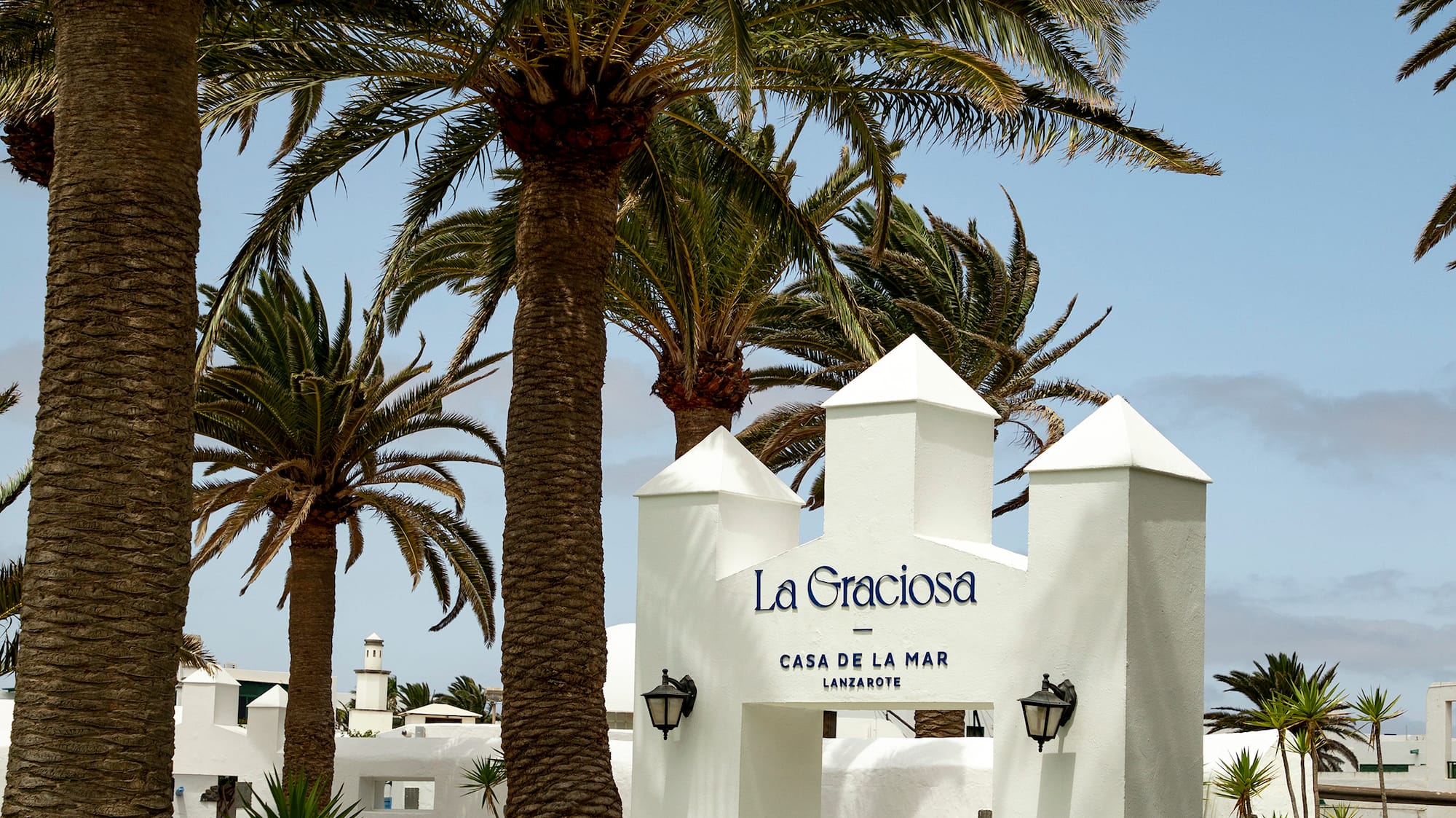 a white sign with a group of palm trees
