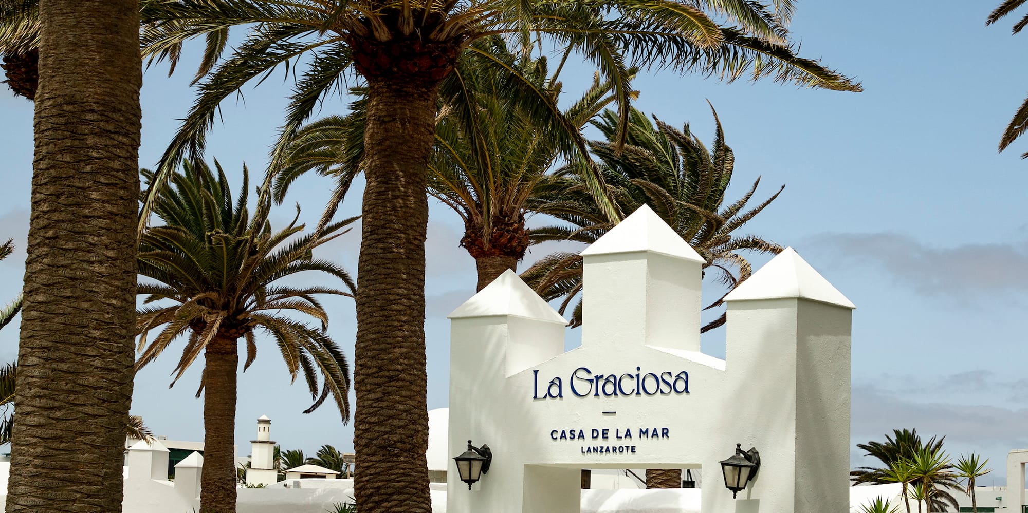 a white sign with a group of palm trees