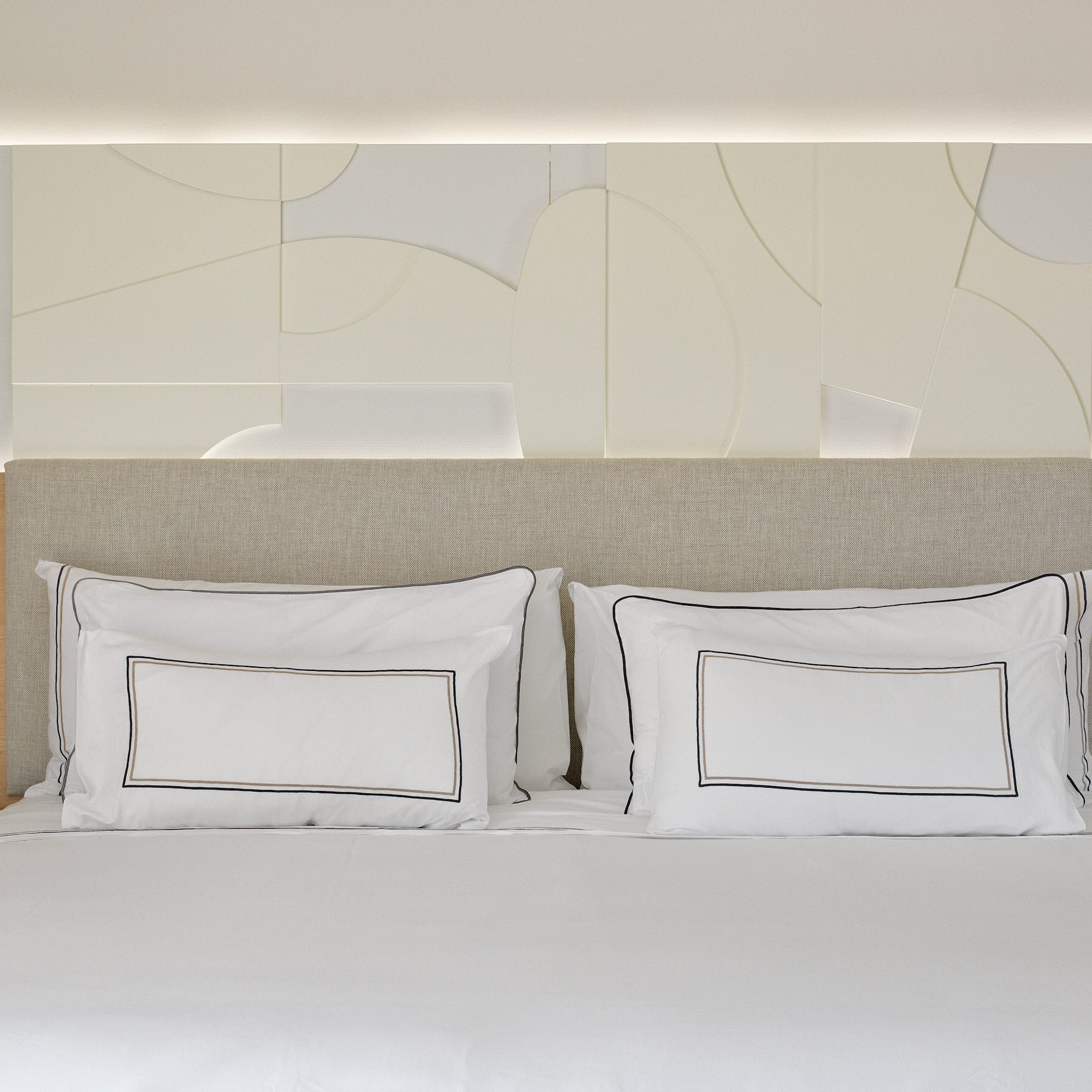 a bed with white sheets and pillows