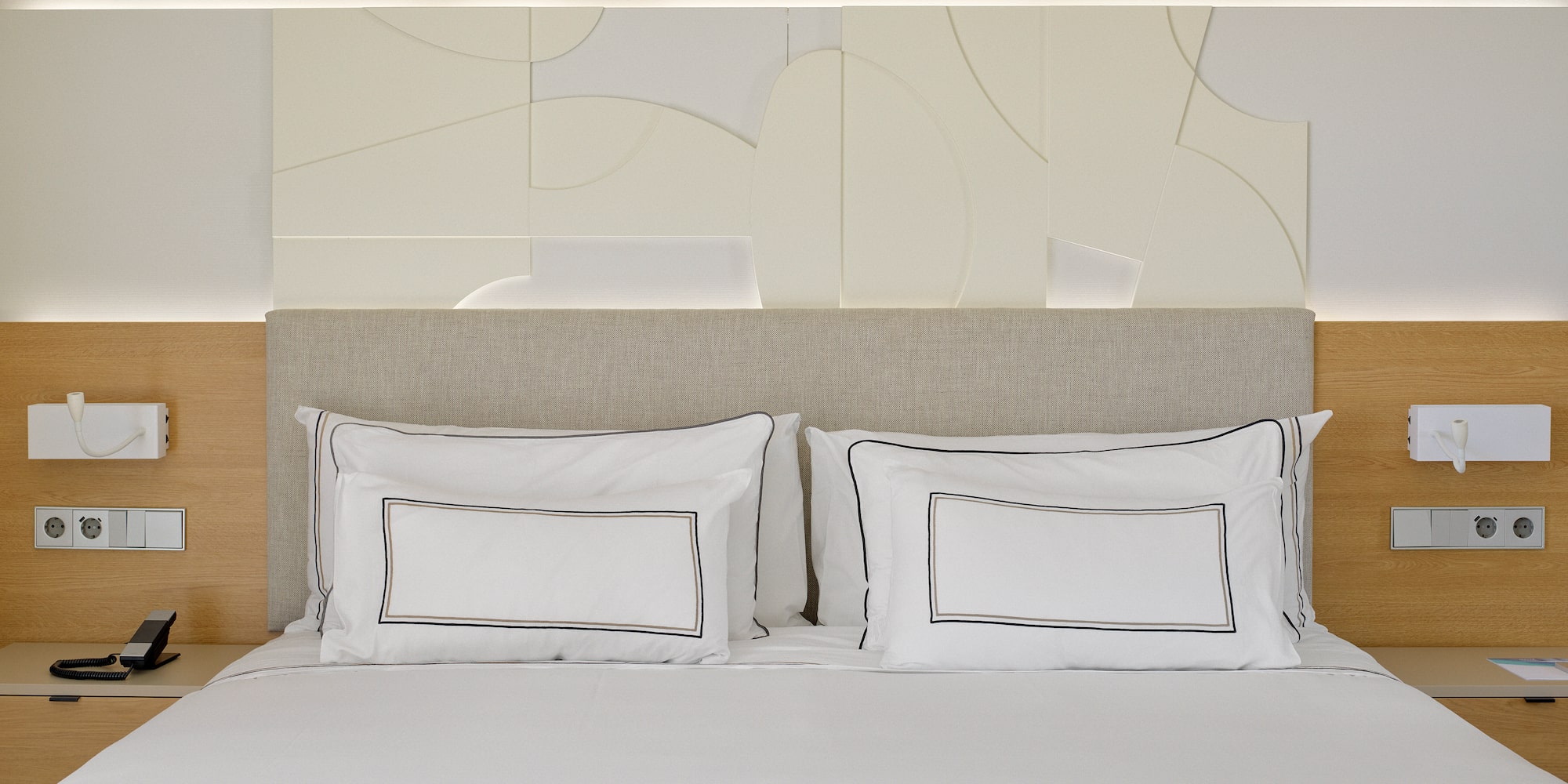 a bed with white sheets and pillows