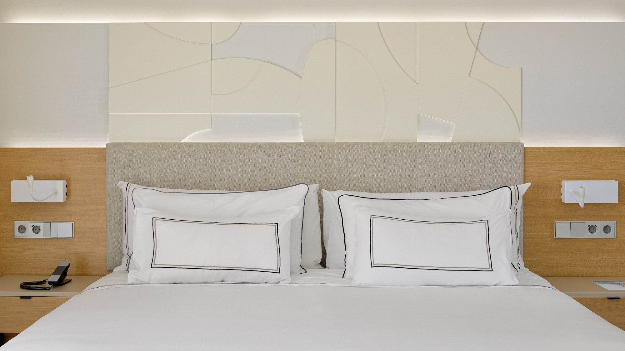 a bed with white sheets and pillows