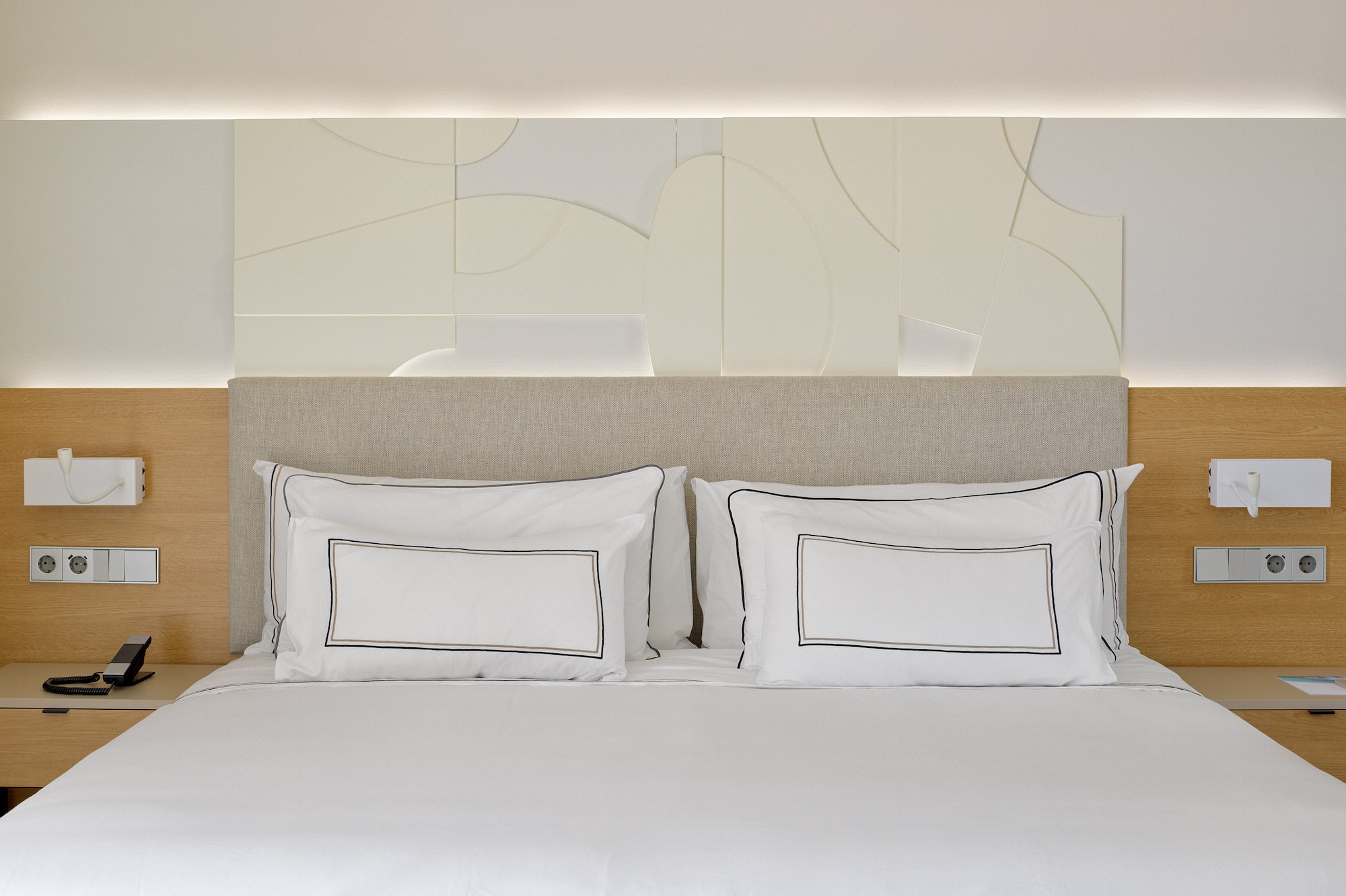 a bed with white sheets and pillows