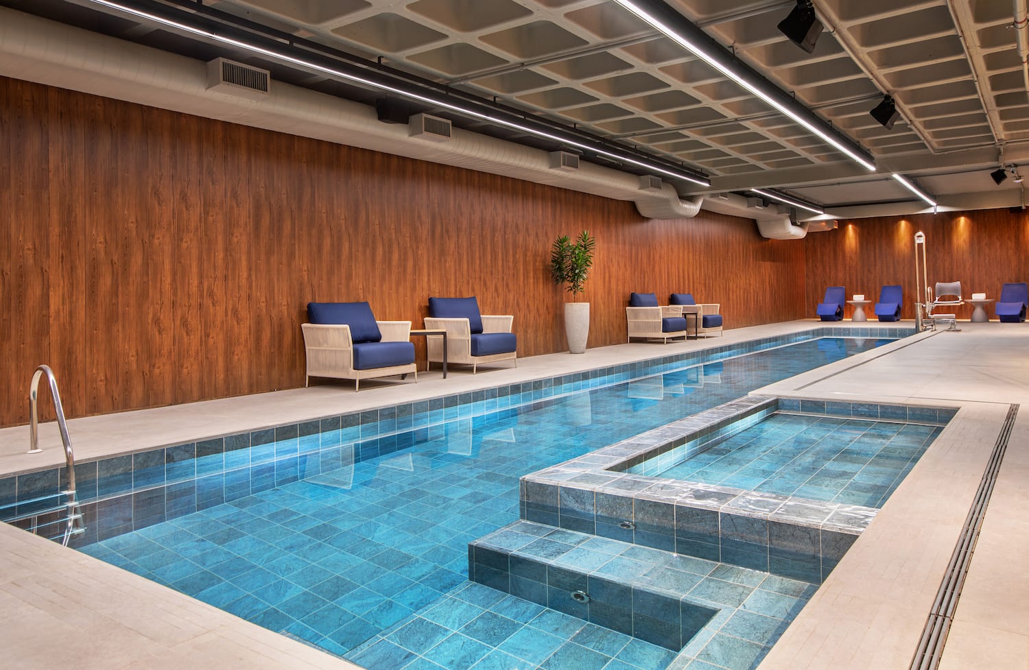 a indoor swimming pool with chairs and a bench