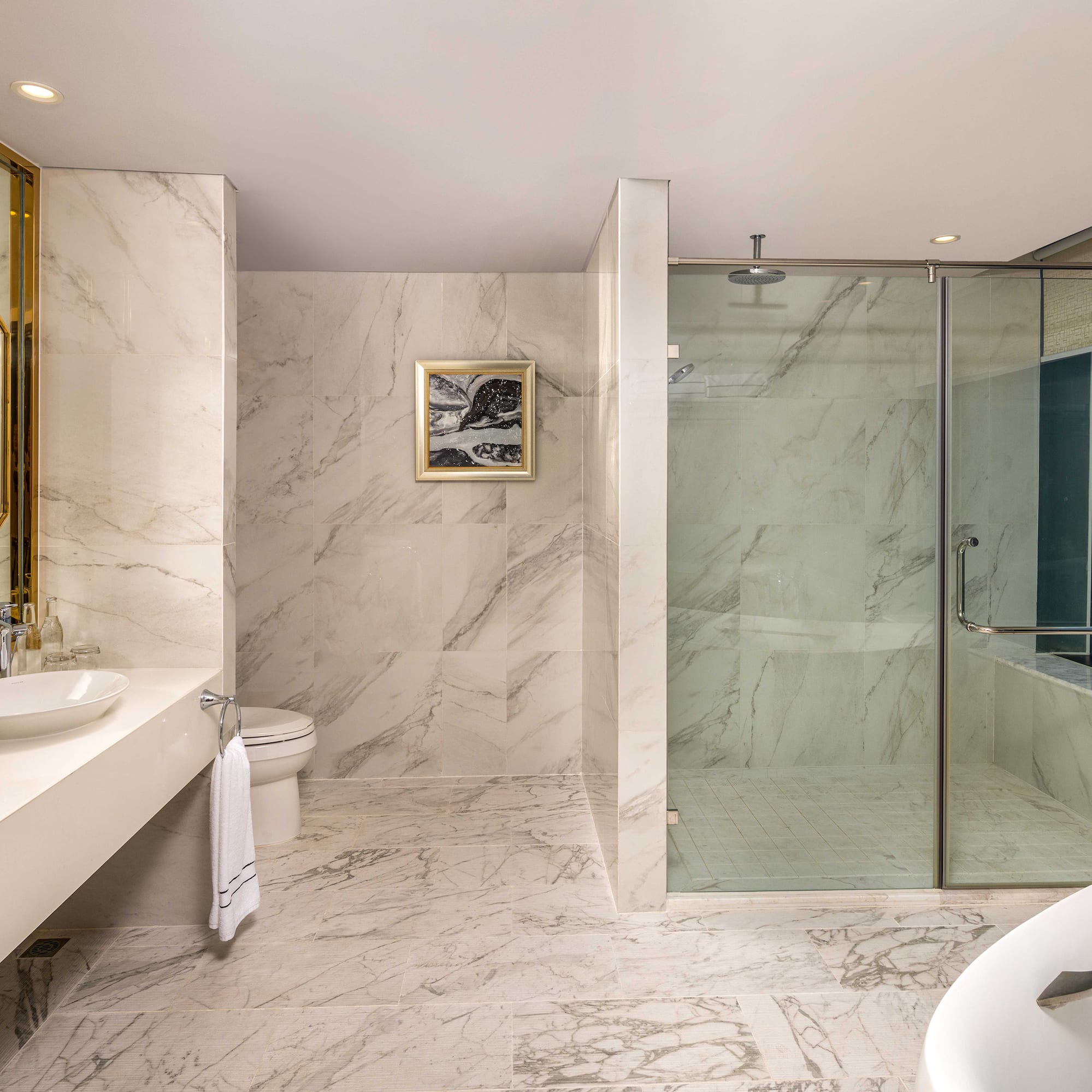 a bathroom with marble walls and a sink and shower