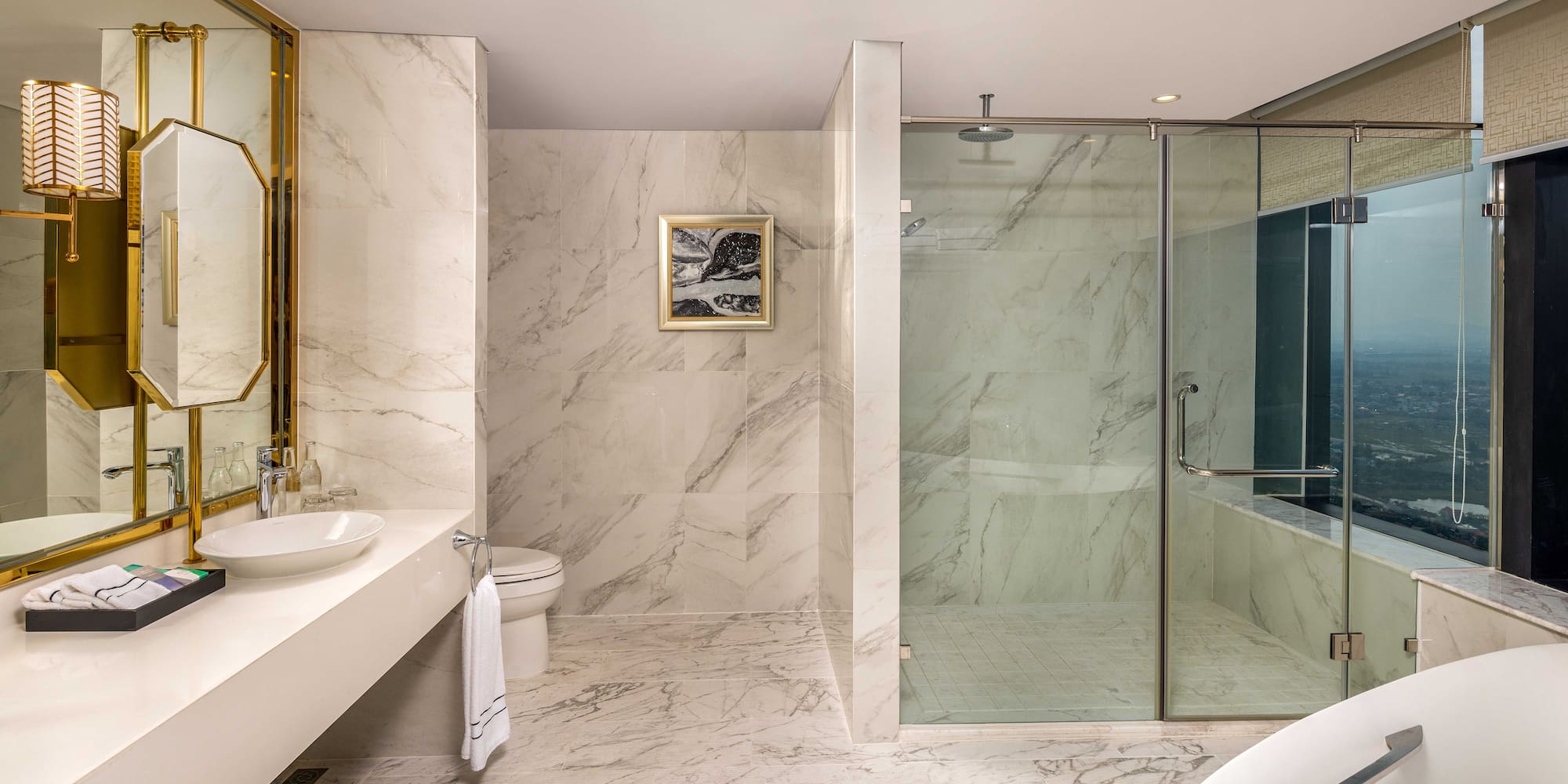 a bathroom with marble walls and a sink and shower