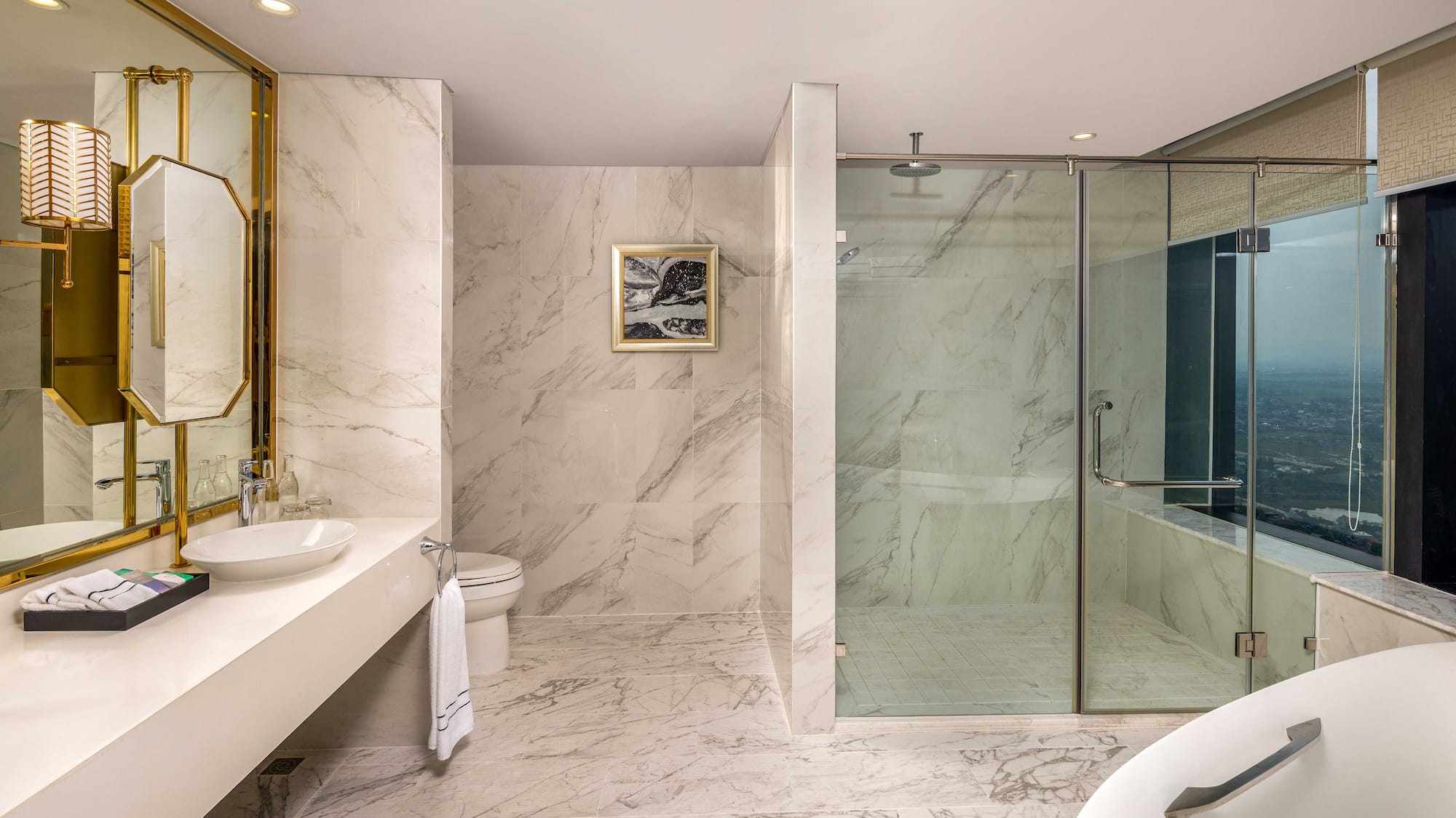 a bathroom with marble walls and a sink and shower