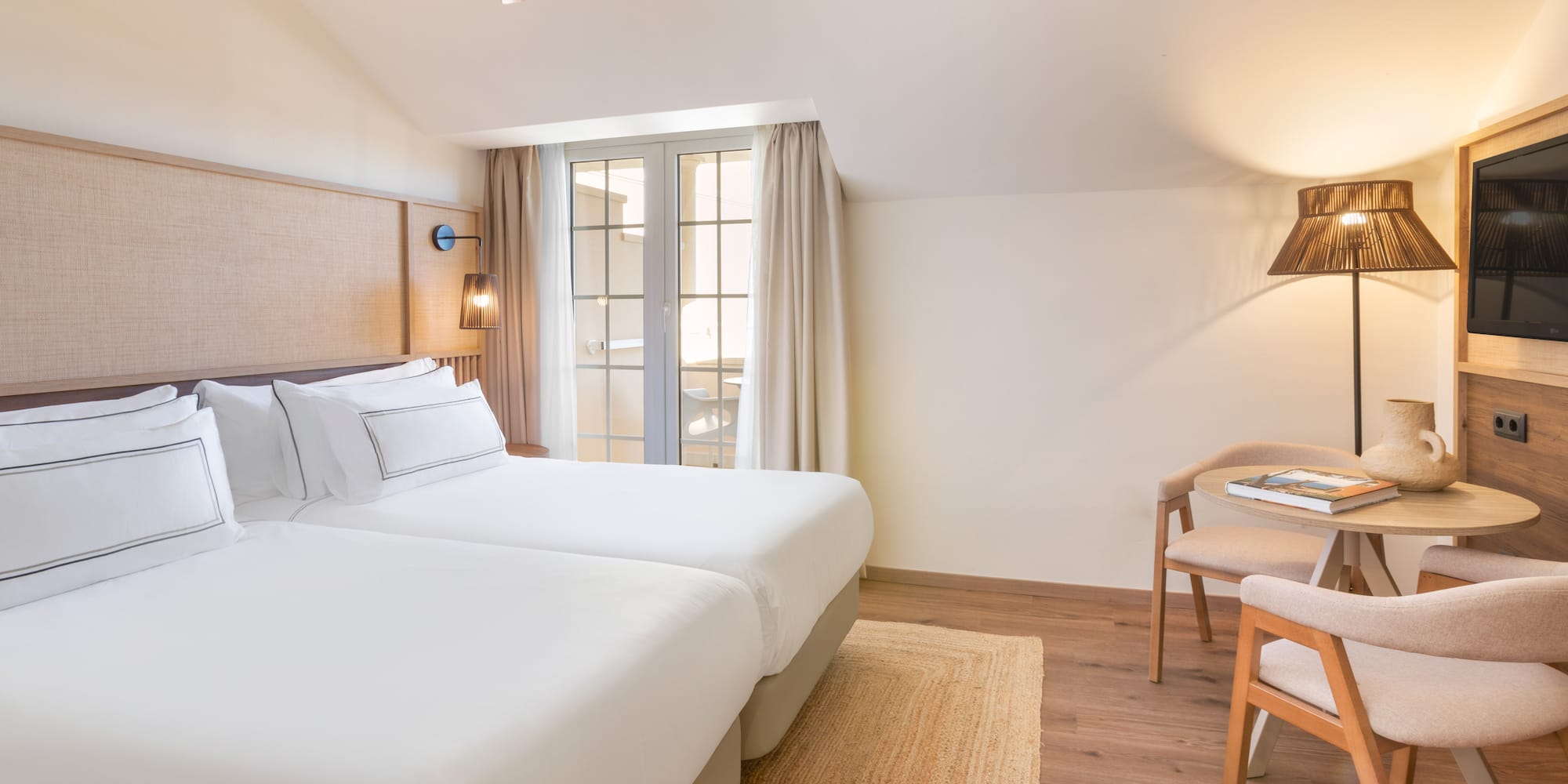 a room with two beds and a table and chairs