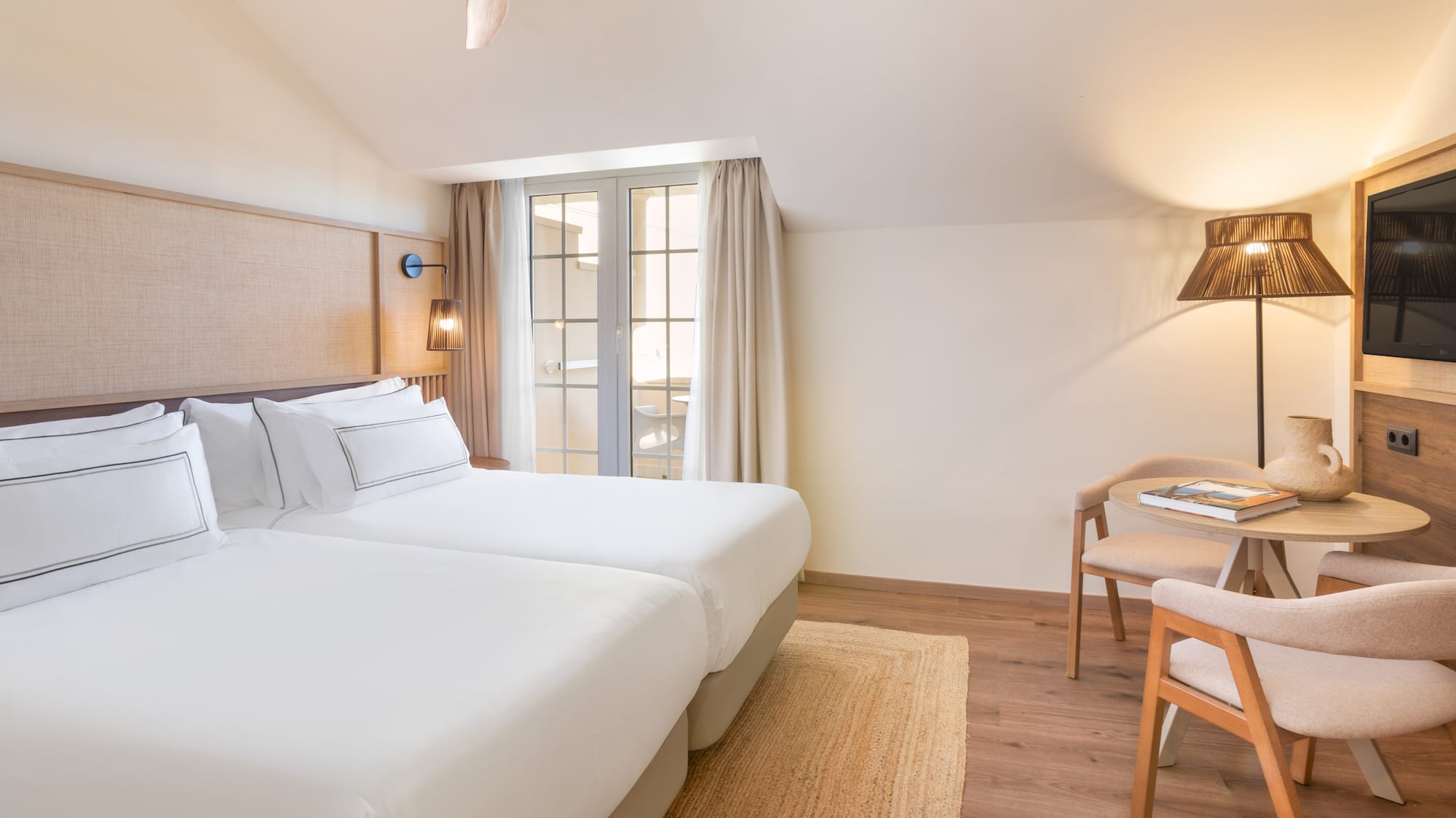 a room with two beds and a table and chairs