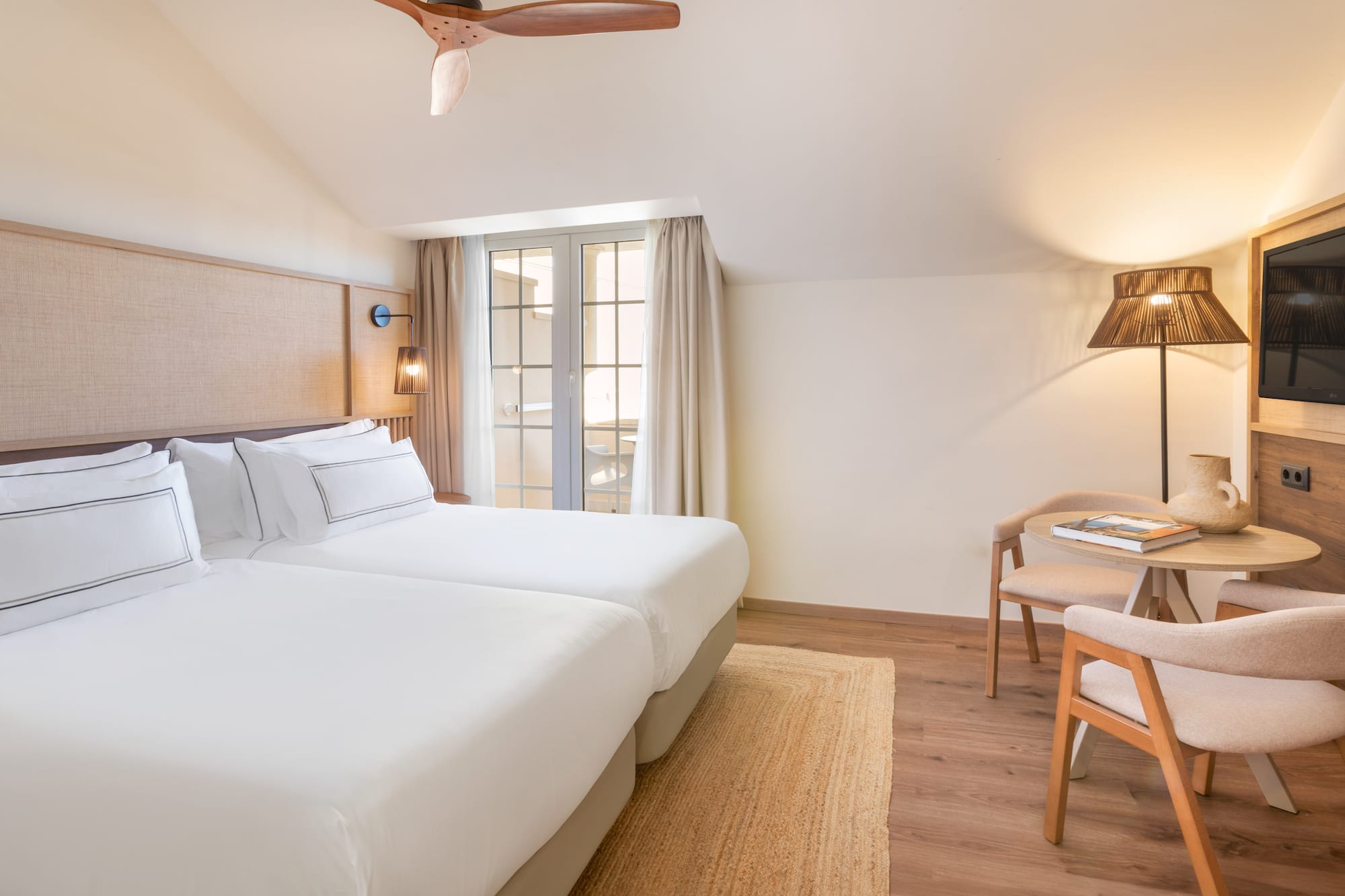 a room with two beds and a table and chairs