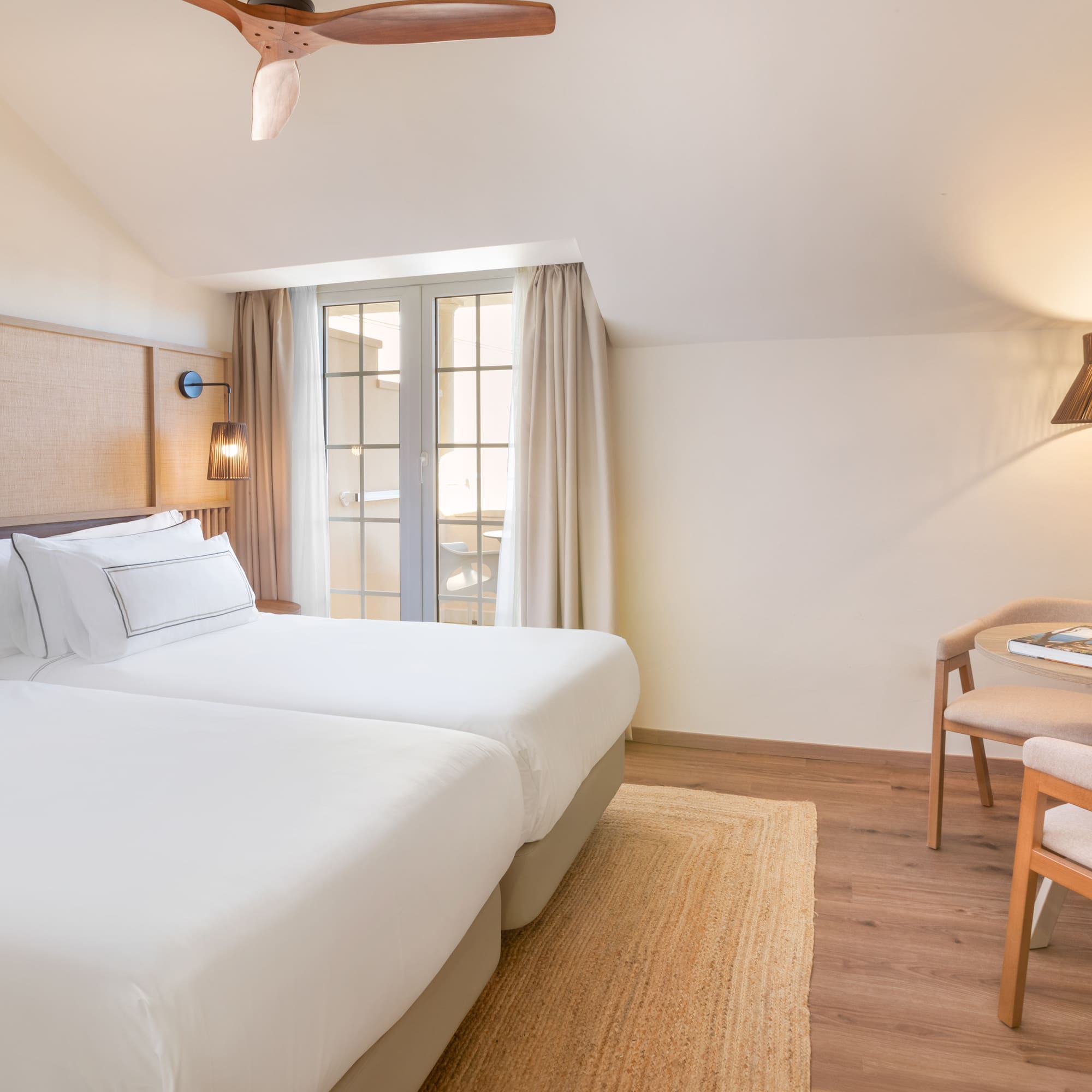 a room with two beds and a table and chairs