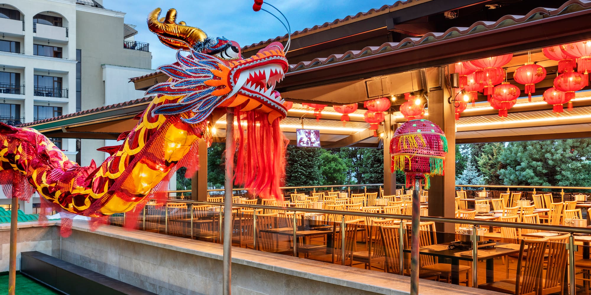a large red and yellow dragon statue outside a restaurant