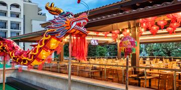 a large red and yellow dragon statue outside a restaurant