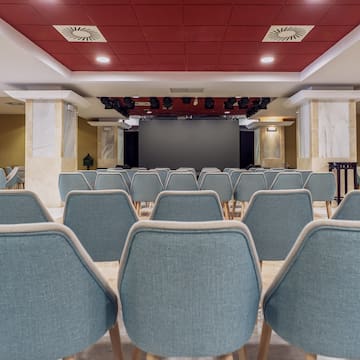 a room with chairs and a screen